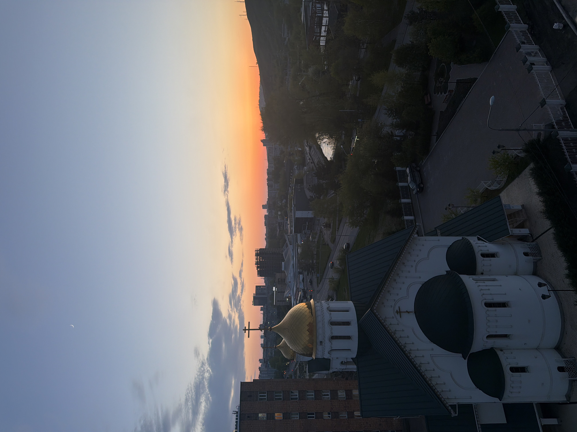 Crescent moon visible during city sunset observation