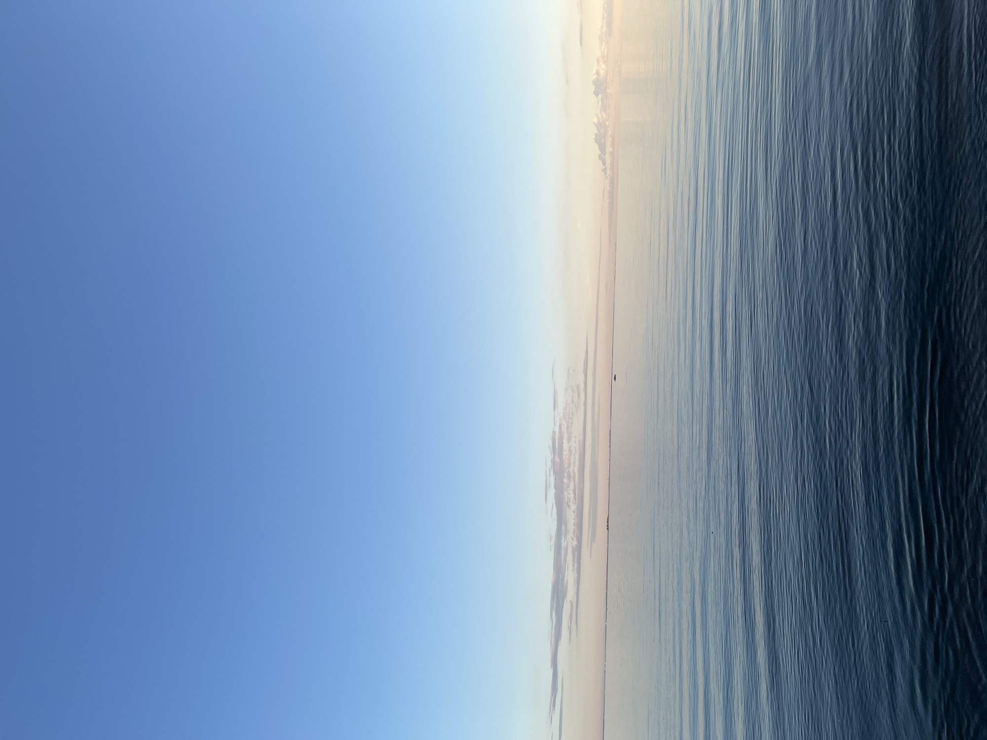 Open water meets clear sky in a calm, minimal scene.