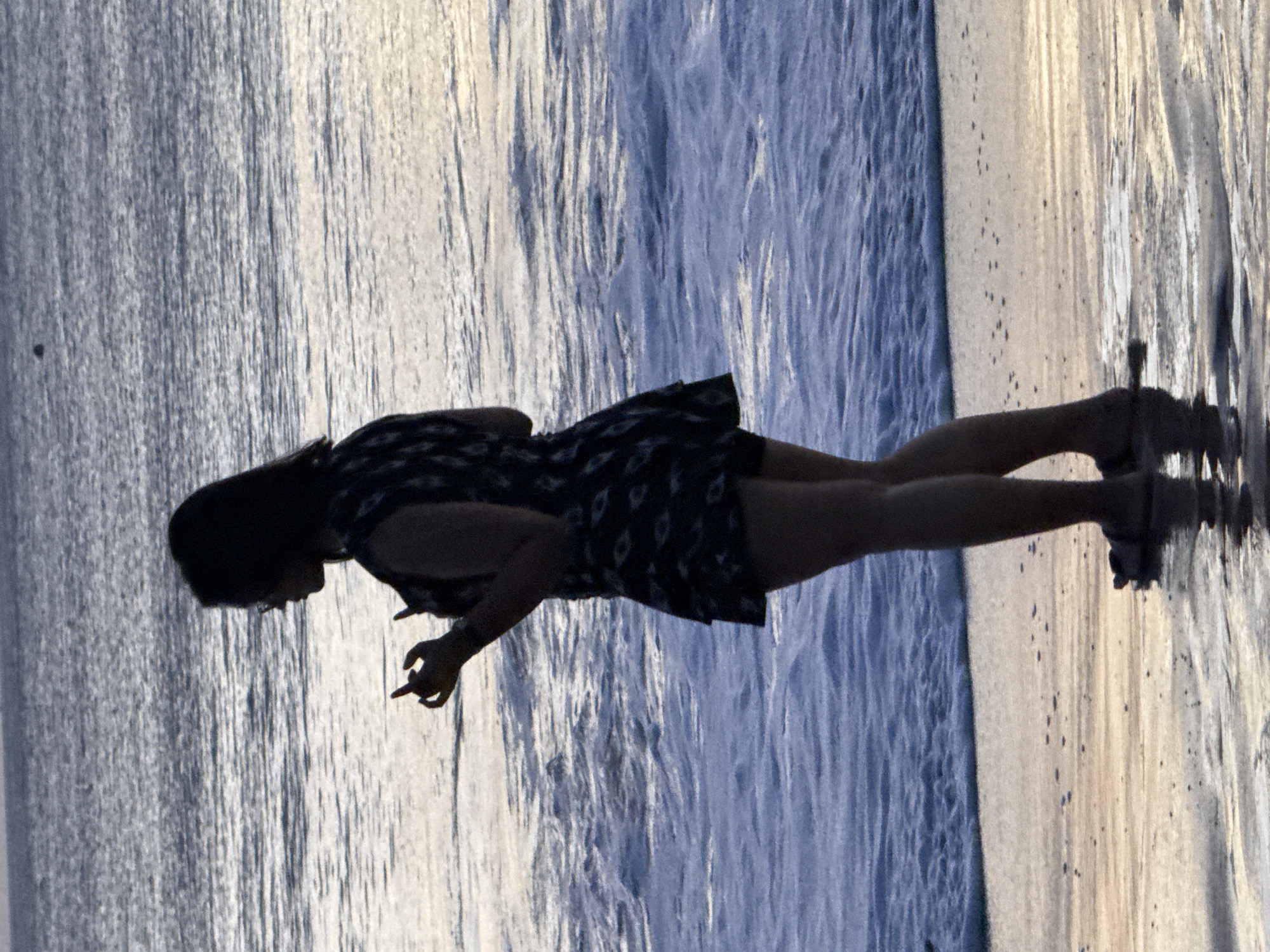 Kuta Beach shoreline activity during golden-hour overcast light