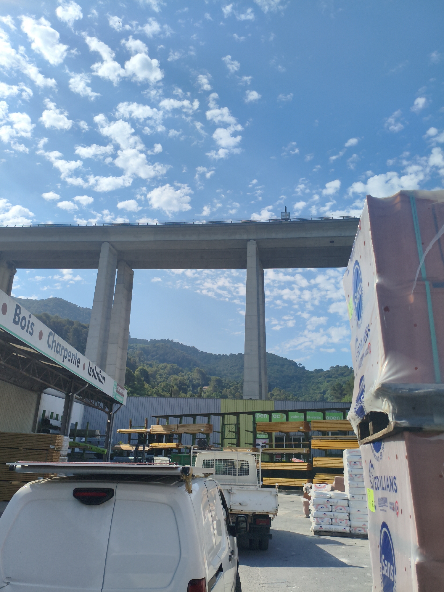 Construction yard sits beneath a highway overpass in La Trinité