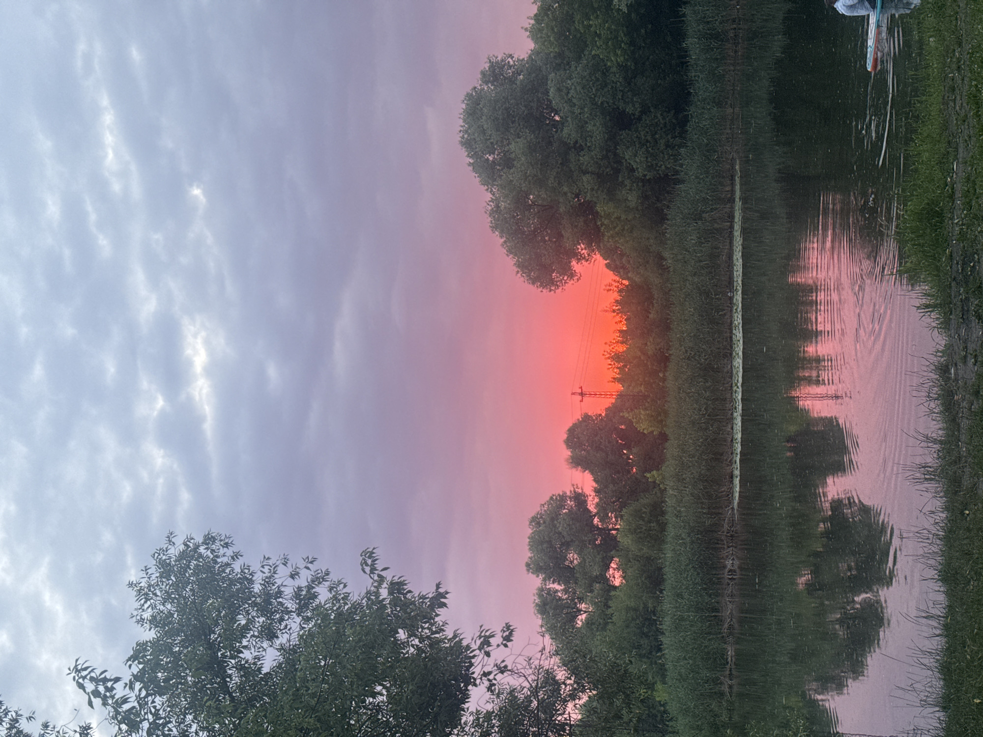Vivid summer sunset reflects over calm Russian waterway