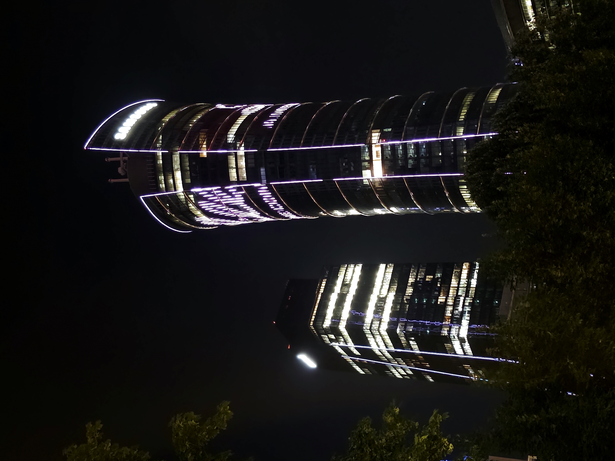 Warsaw's Rondo Daszyńskiego district glowing on a rainy night