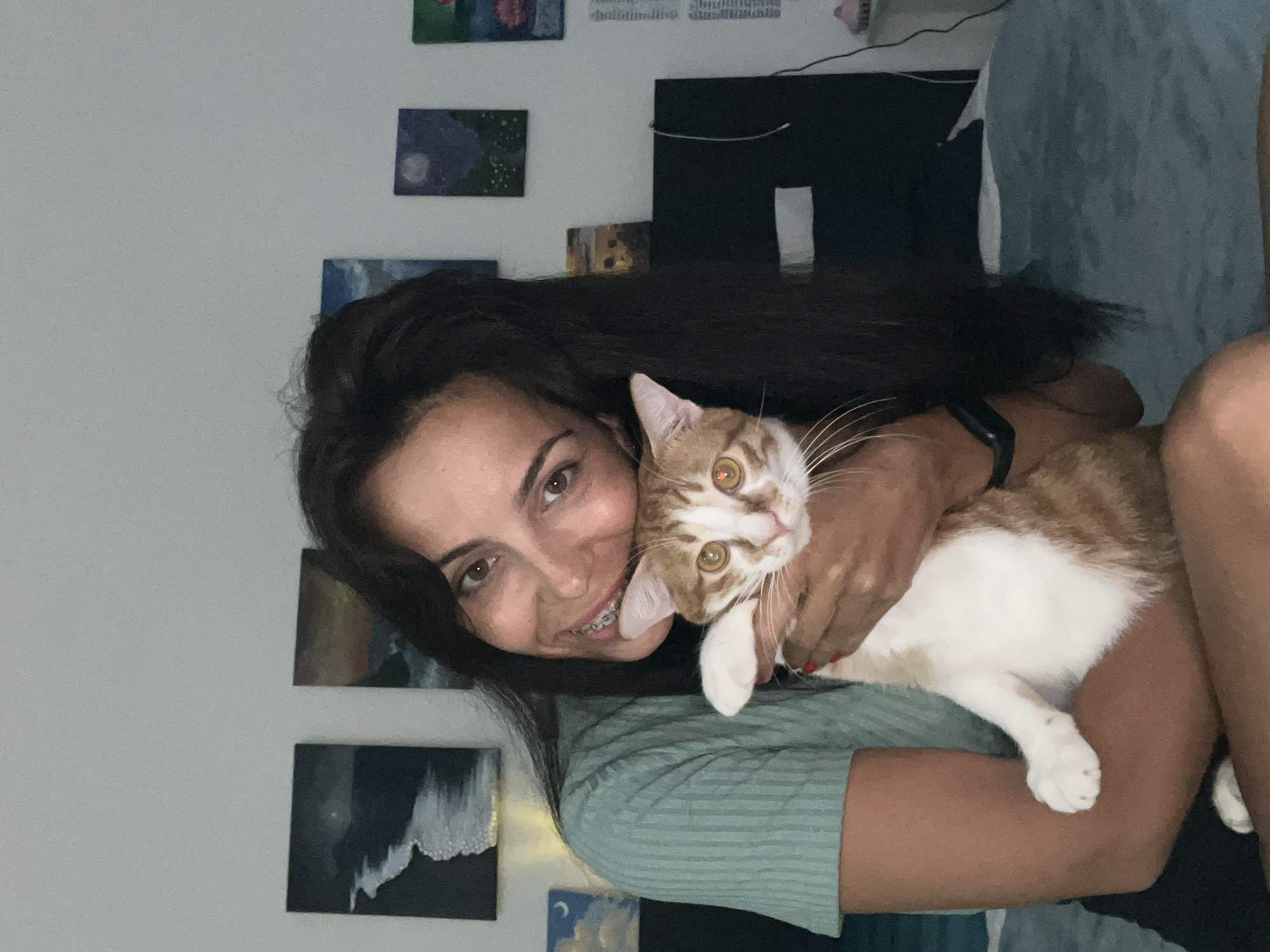 Woman takes selfies with orange cat in Indonesian home