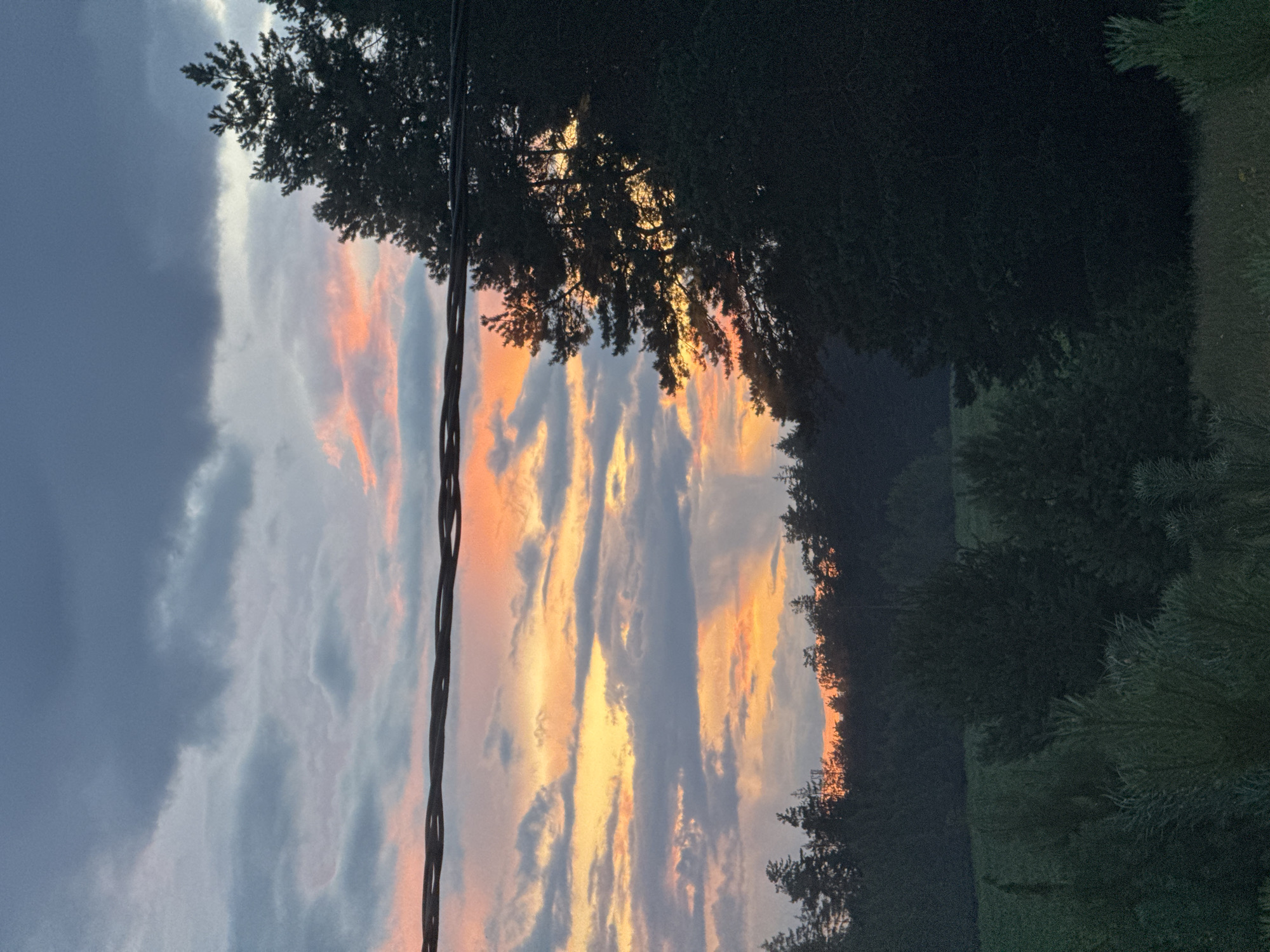 Sunset sky over rural Belarus, clouds lit orange at dusk.