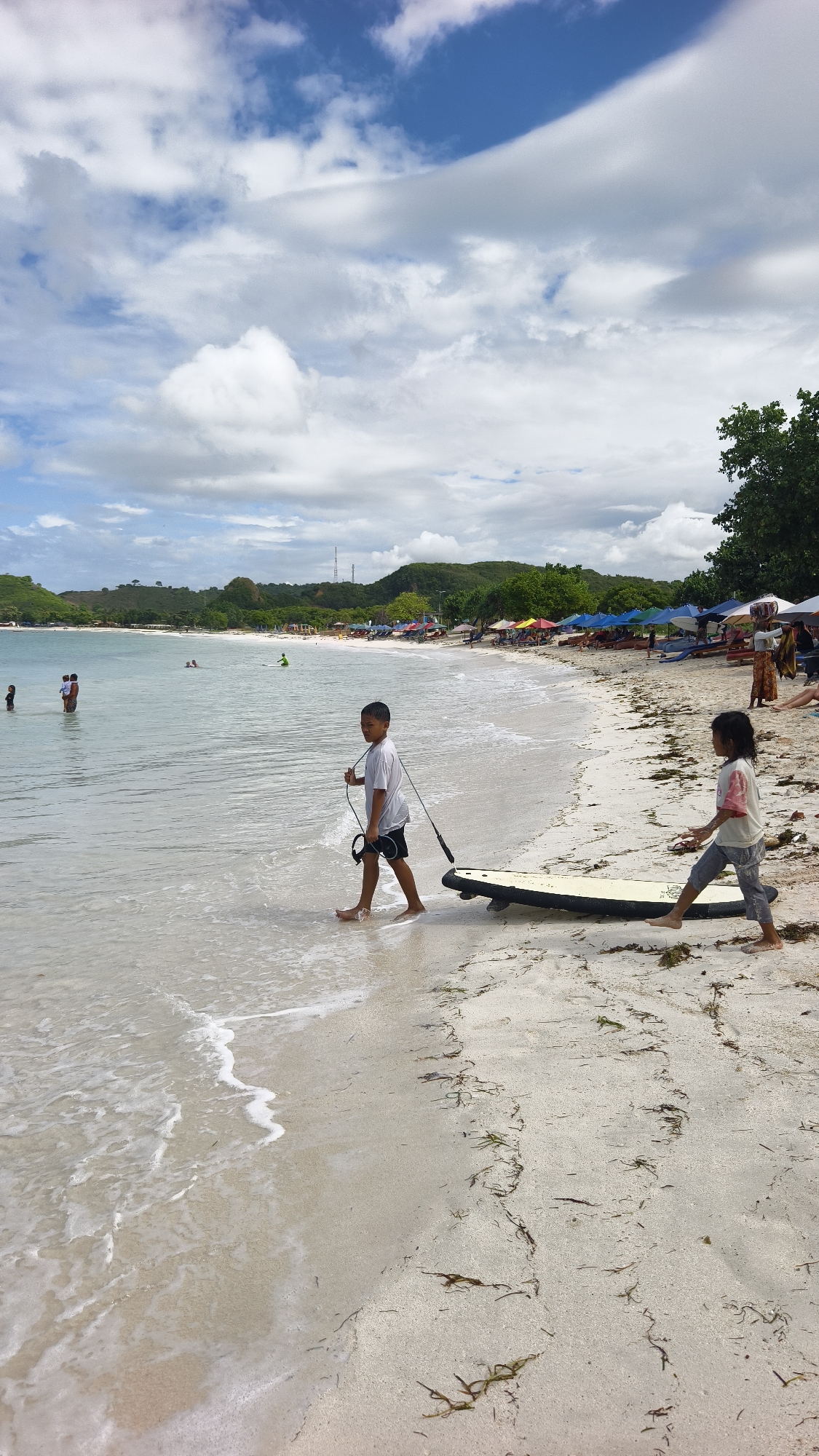 Children play on Kuta beaches during early morning hours