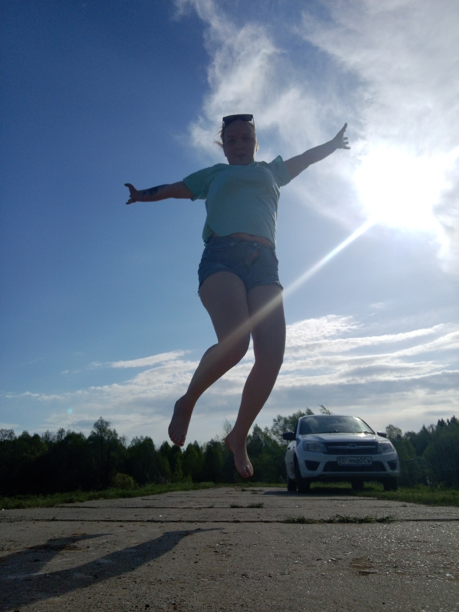 Woman performs outdoor poses near waterway in Уральское, Russia