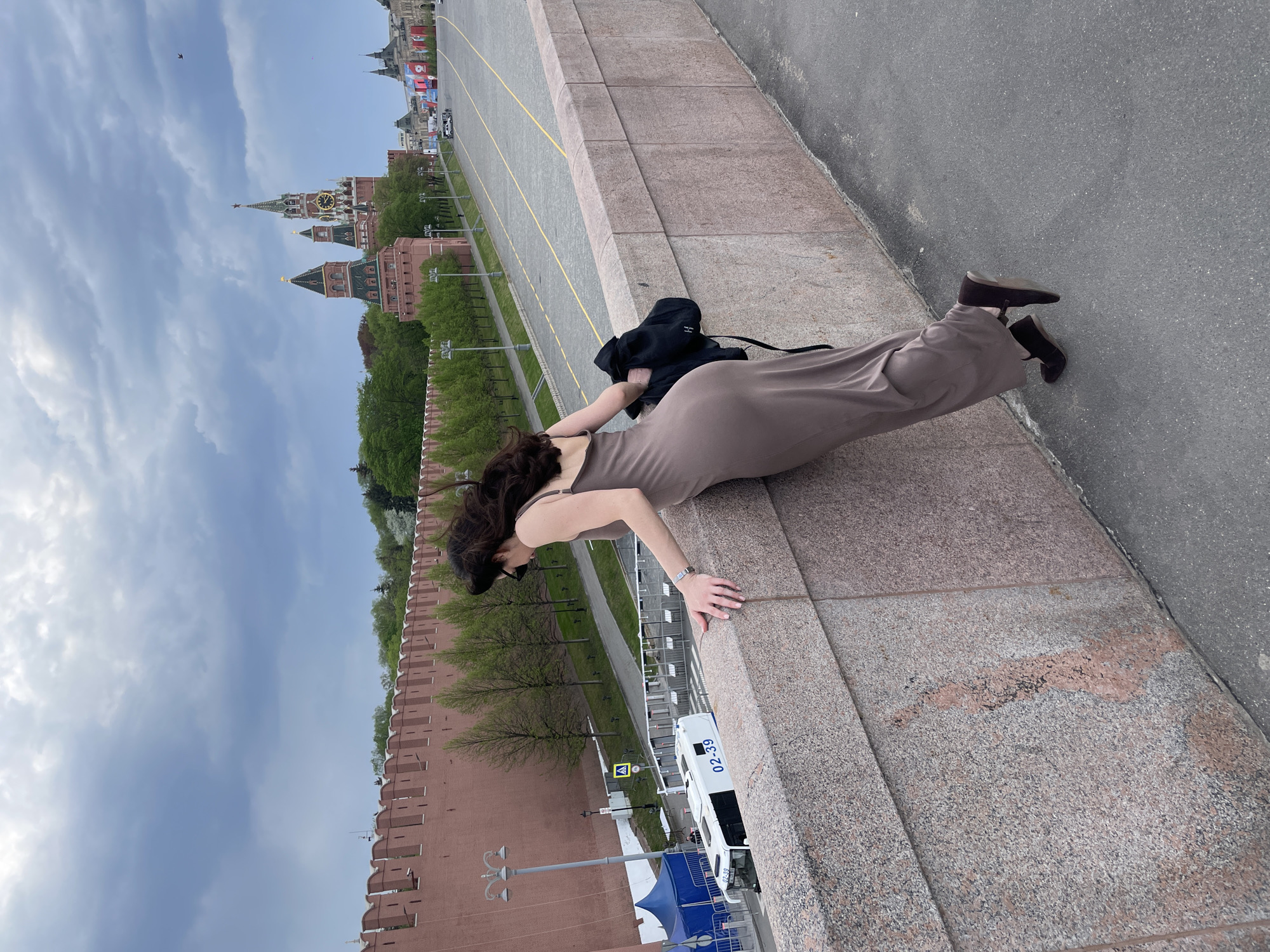 Woman leans over stone wall near Kremlin in Moscow