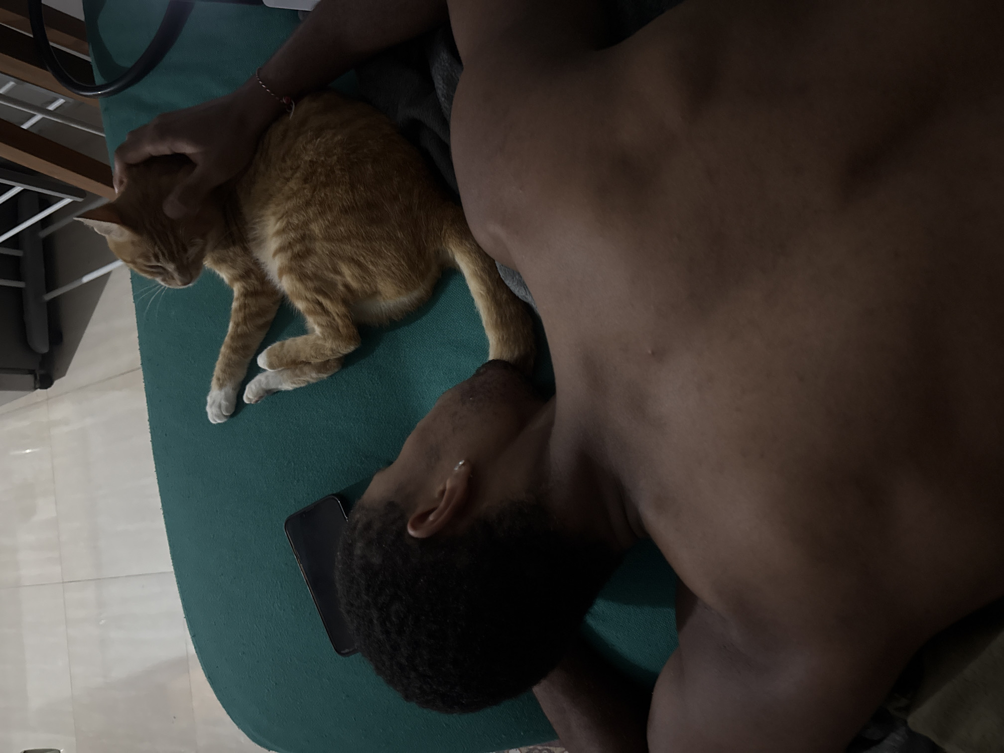Man rests with cat on back in Pejeng home