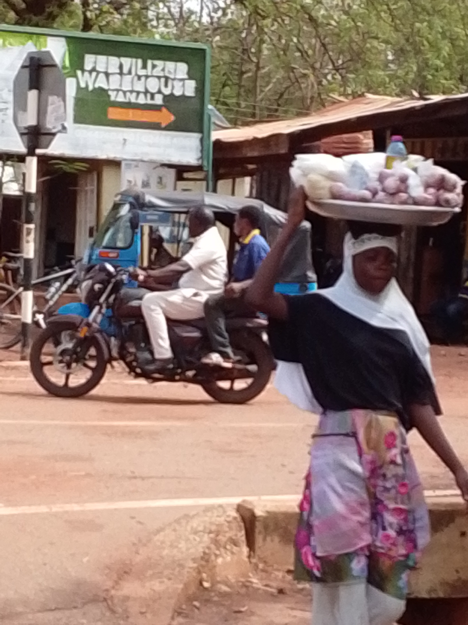 Woman carries food tray on head in Tamale street