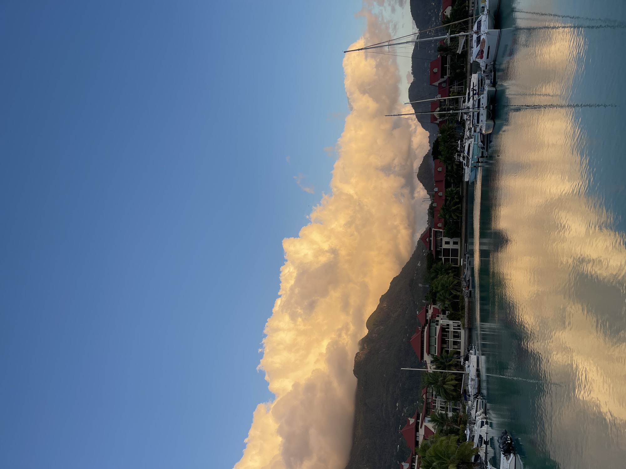 Golden-hour clouds hang over Victoria's calm marina, Seychelles