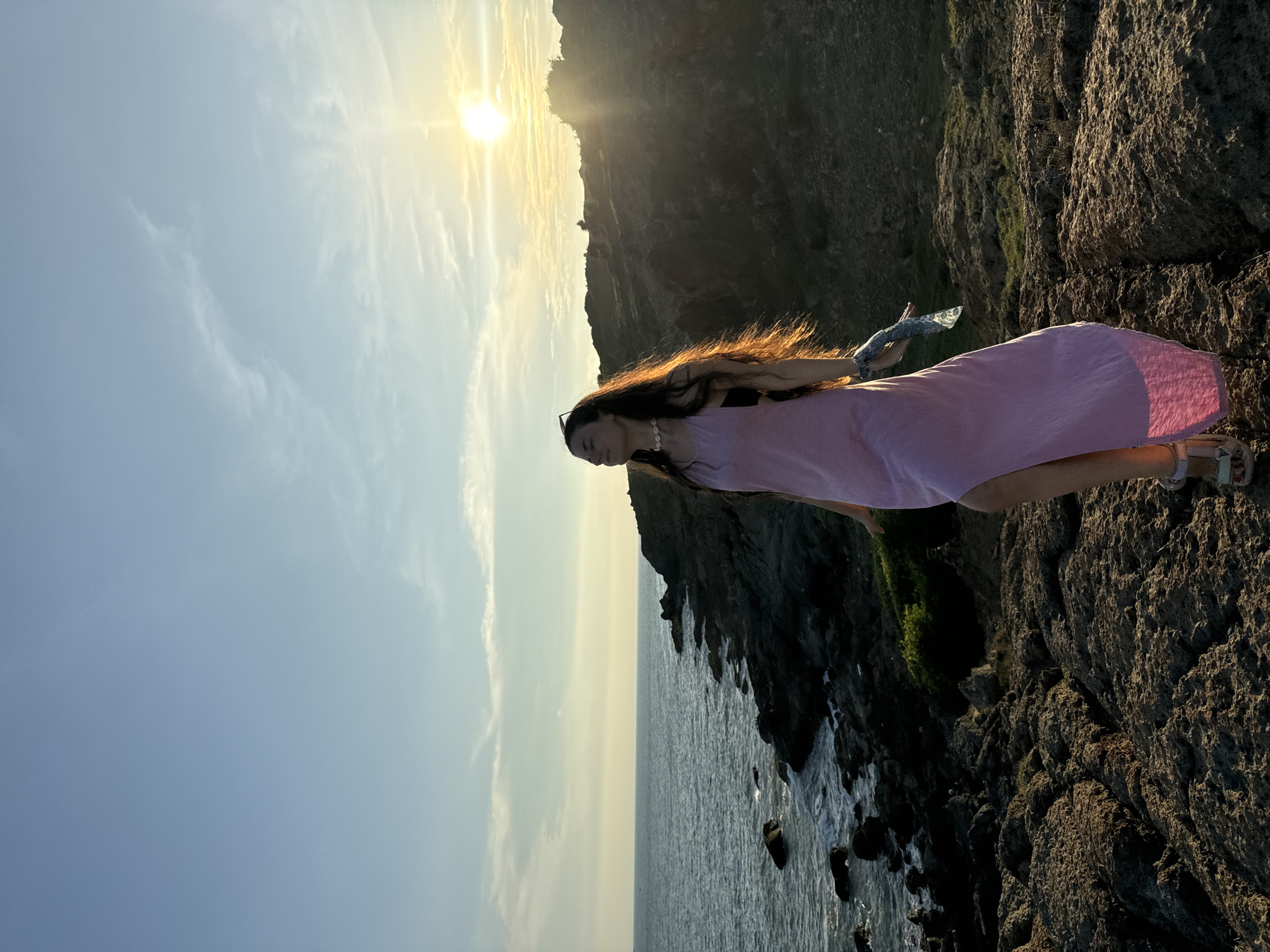 Women pose for photos on Mui Ne coastline at sunset
