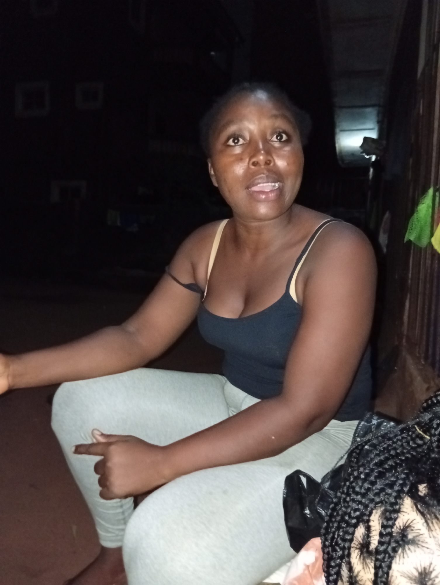 Woman gesturing while sitting in Ogidi, Nigeria