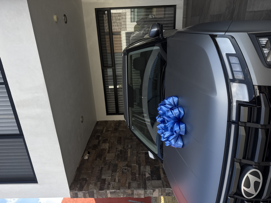 Woman poses with bow-decorated SUV in Puebla driveway