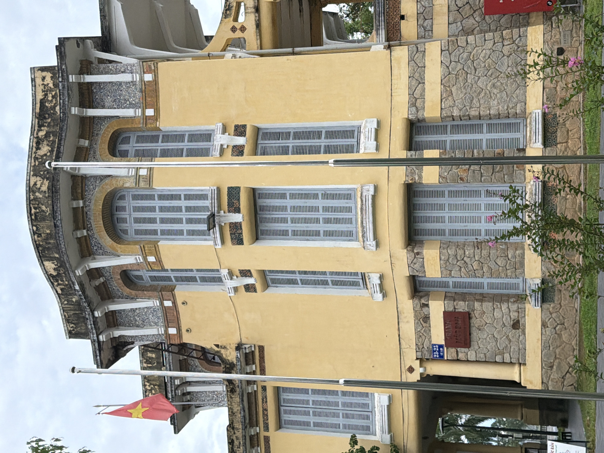 Yellow colonial building with Vietnamese flag, Thuận Hóa Ward