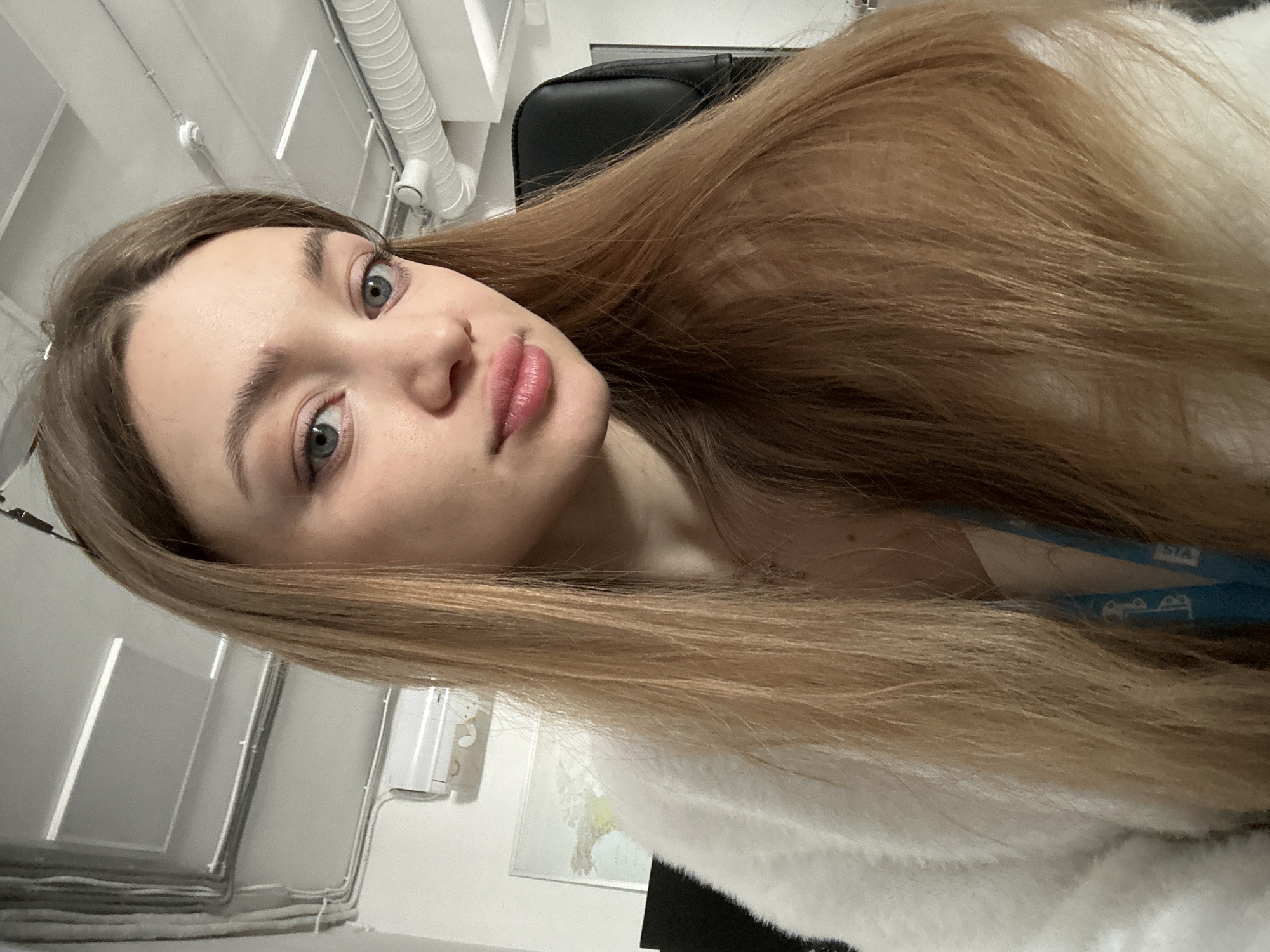 Young woman photographed indoors with flowing light brown hair