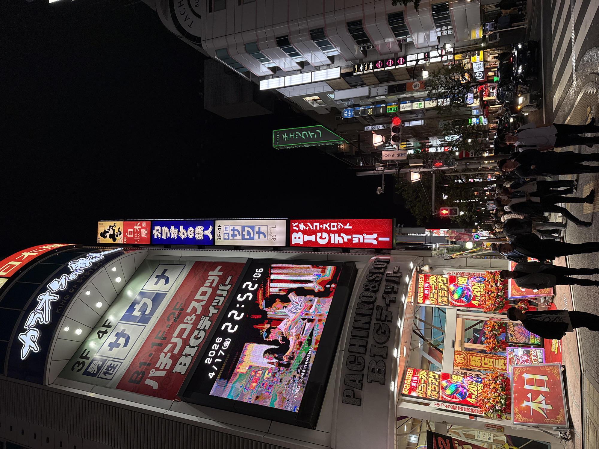 Evening street life continues in Minato's neon-lit districts