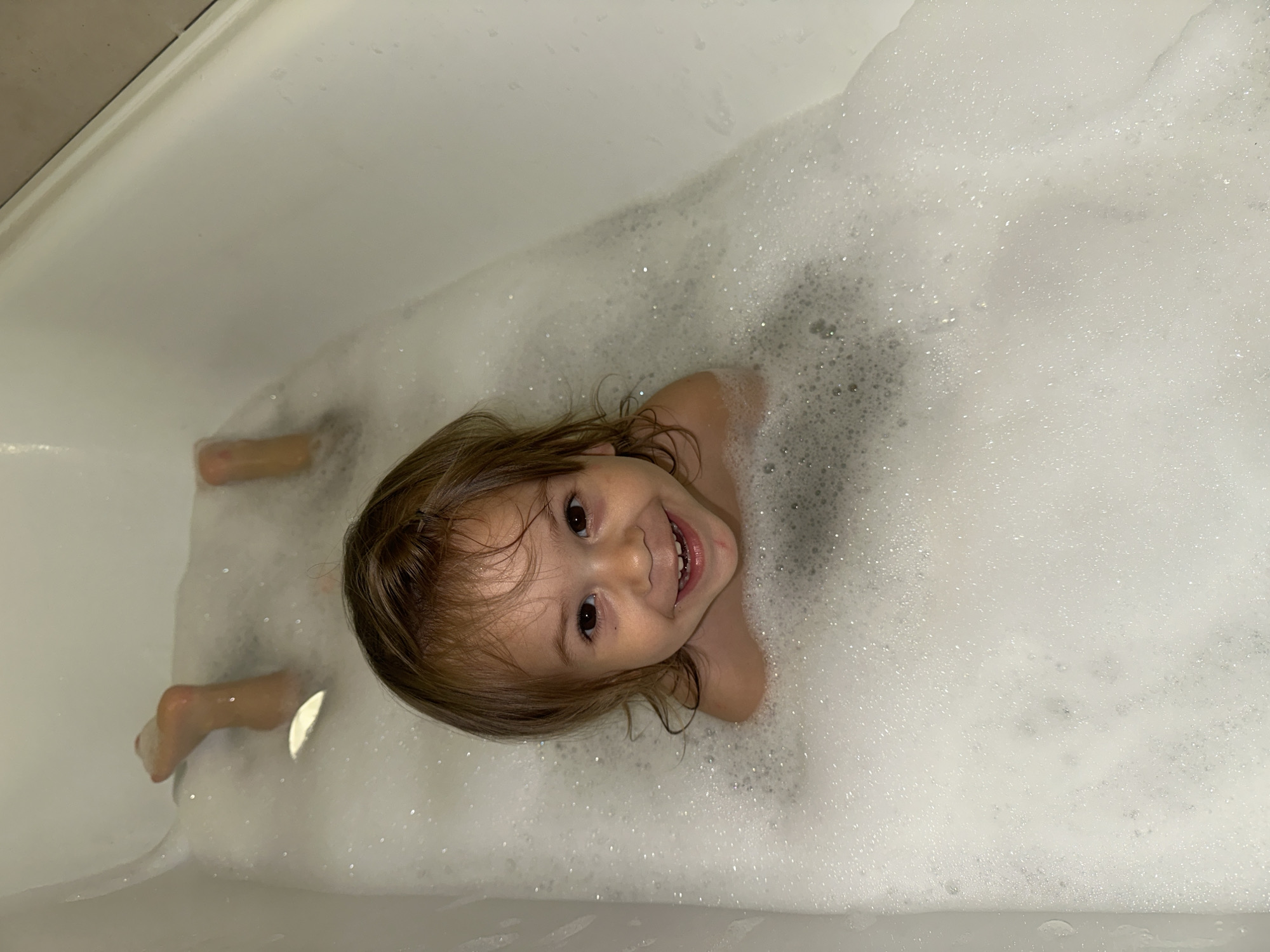 Toddler enjoys bubble bath with starfish toy in Kharnavy