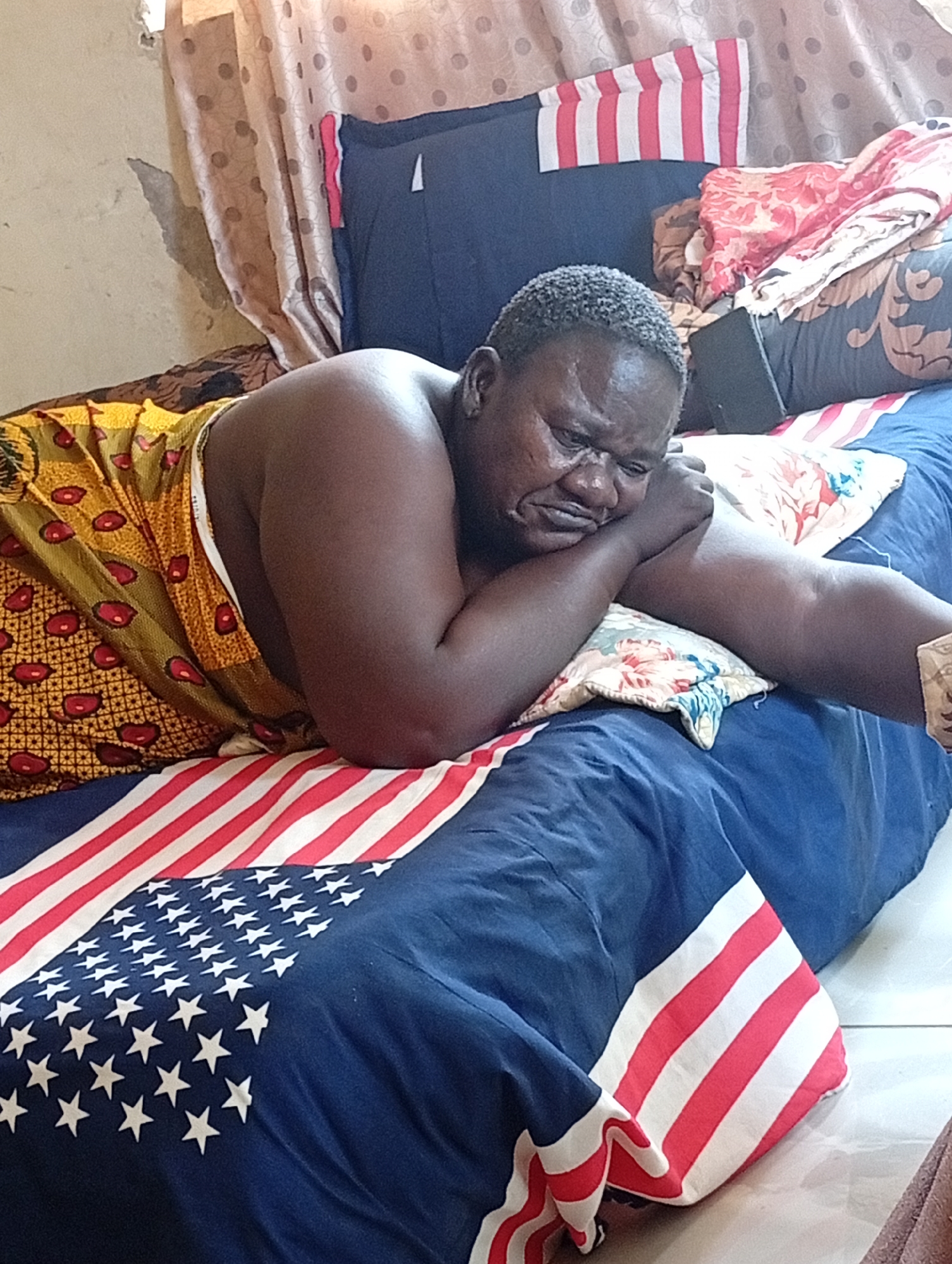 Man resting on bed in Sabon Tasha, Nigeria