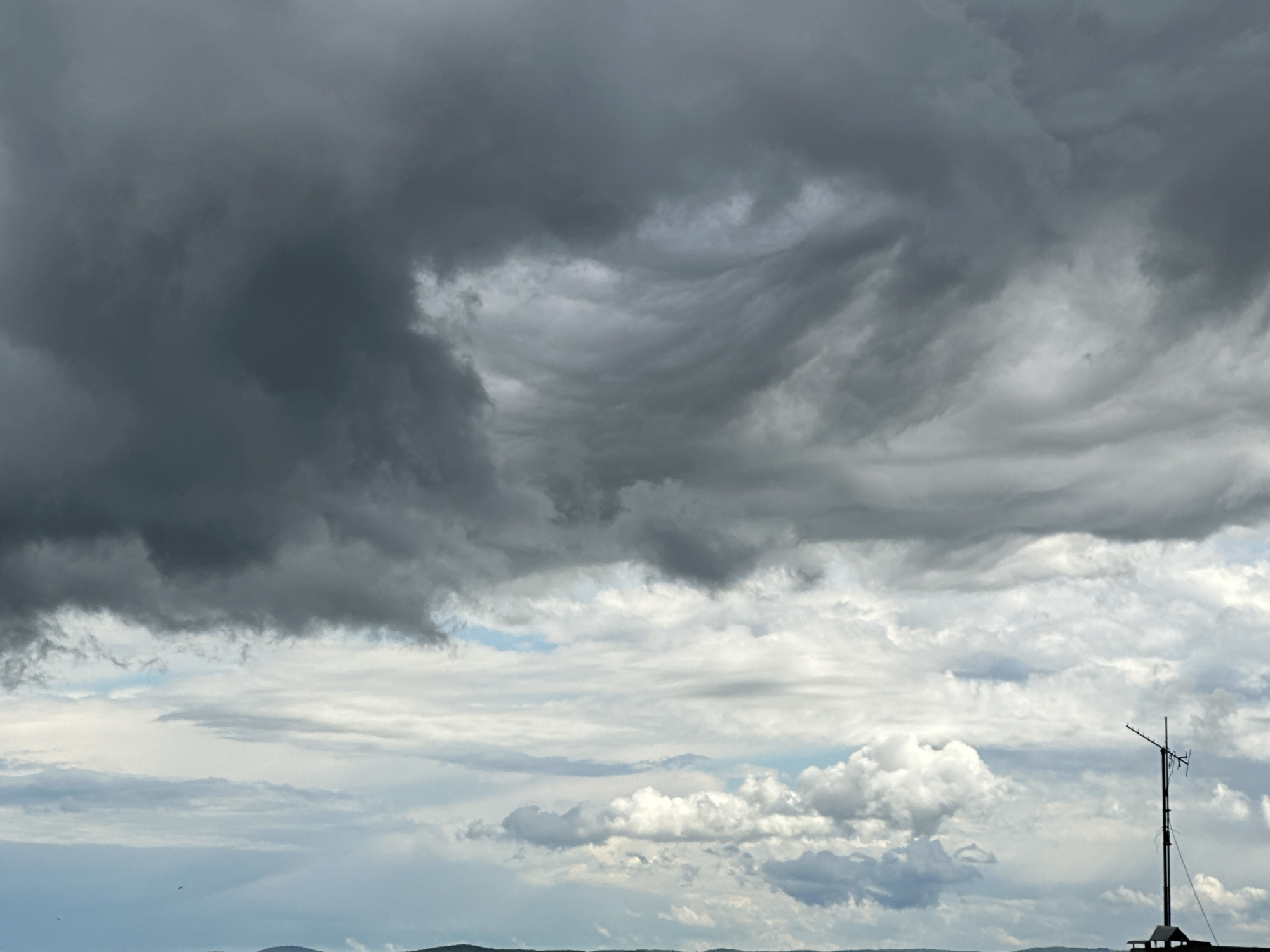 Storm clouds gather over rural landscapes and cities