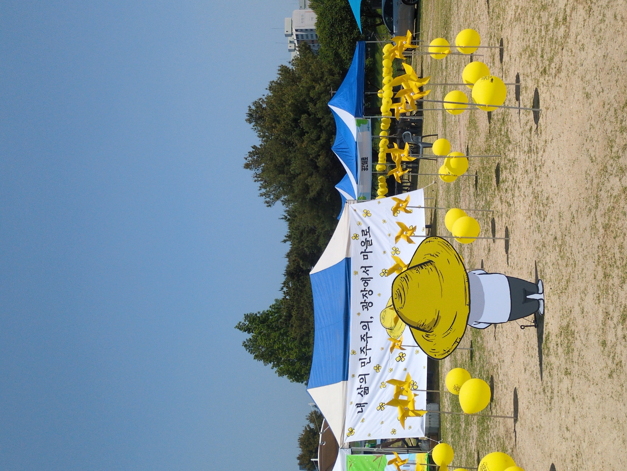 Early morning outdoor event with tents, pinwheels in Daejeon park