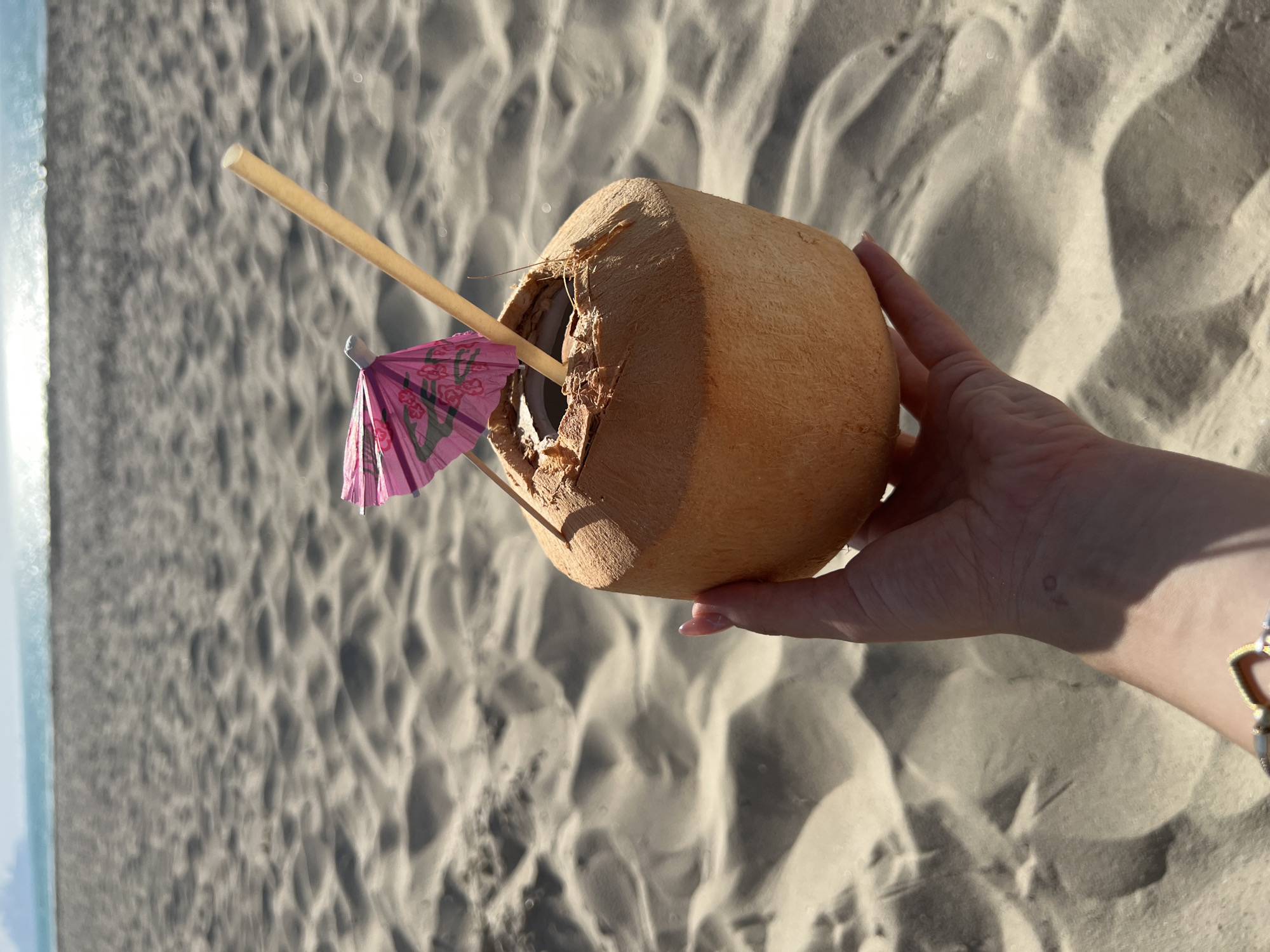 Tourist enjoys coconut drink on Abu Dhabi beach