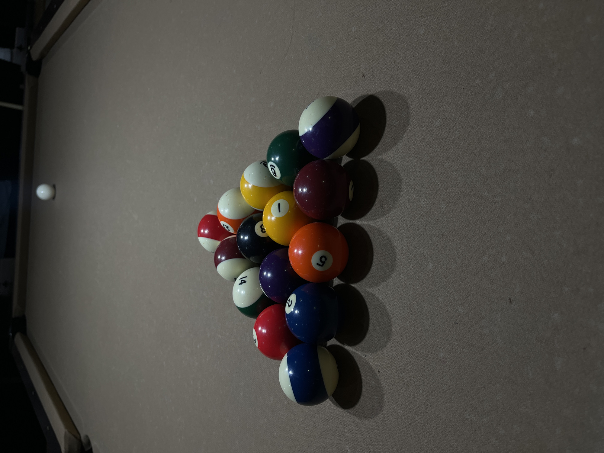 Pool balls racked on billiard table captured indoors