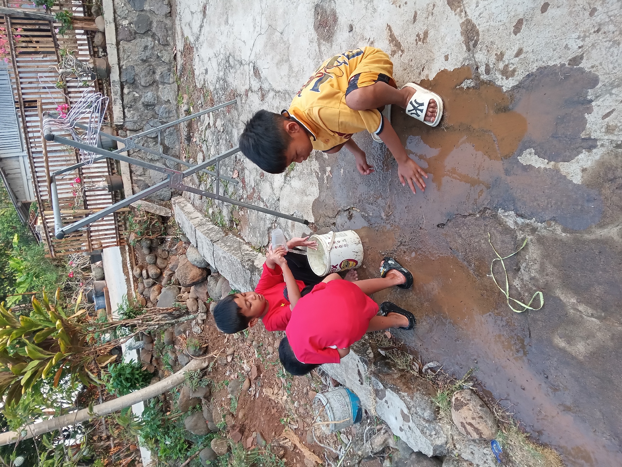 Kids playing in a muddy yard in rural Kedunggudel, Indonesia