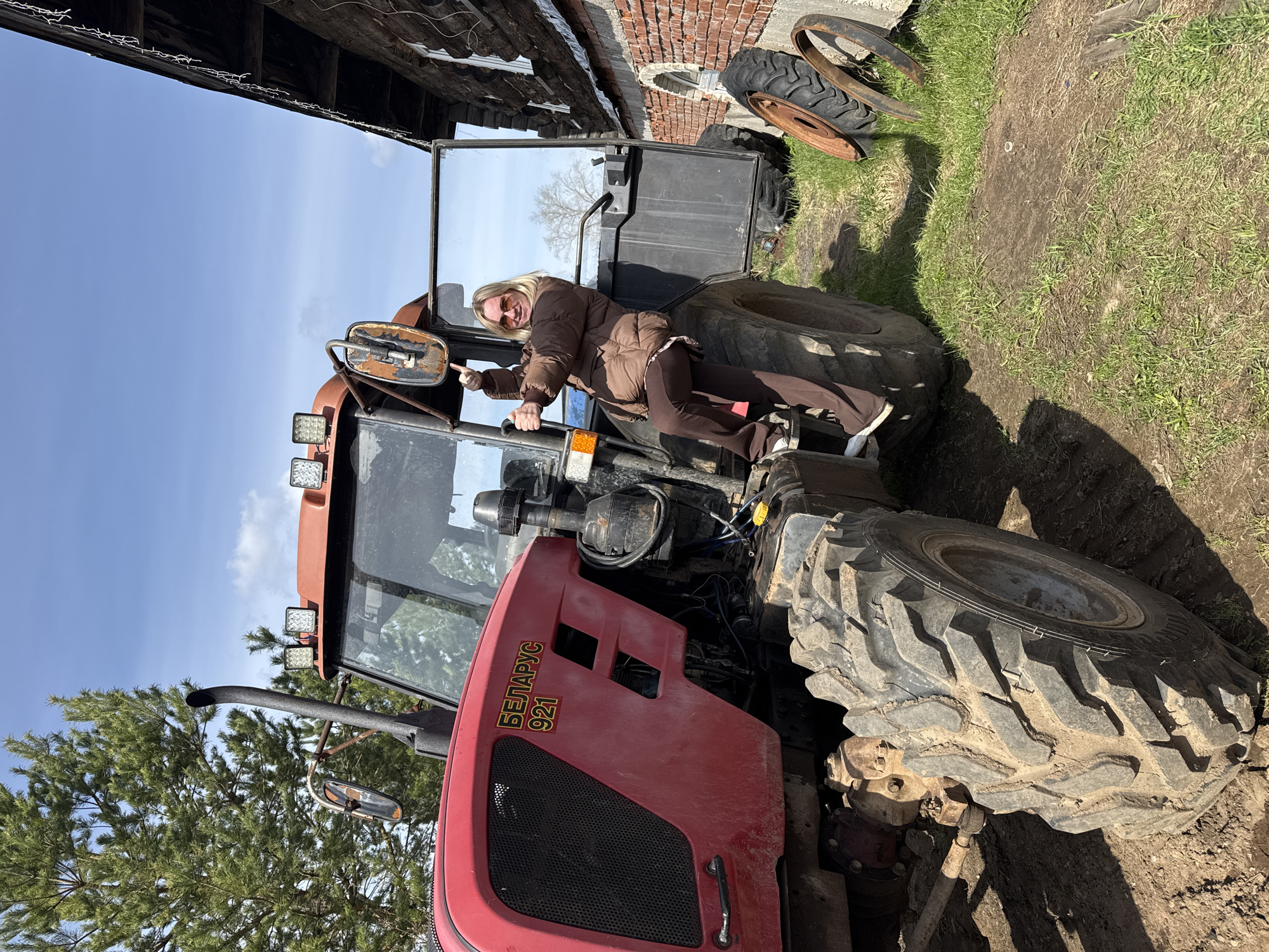 Woman poses with farm equipment in rural Russia