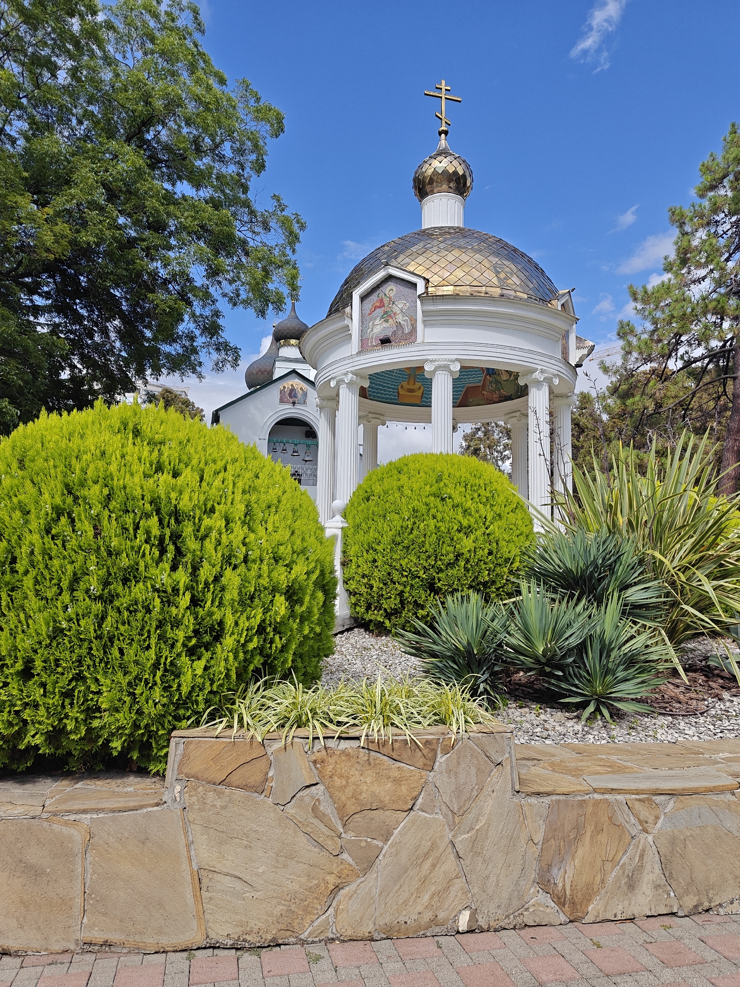 Military memorial park with sculptures, a tank, and a domed gazebo