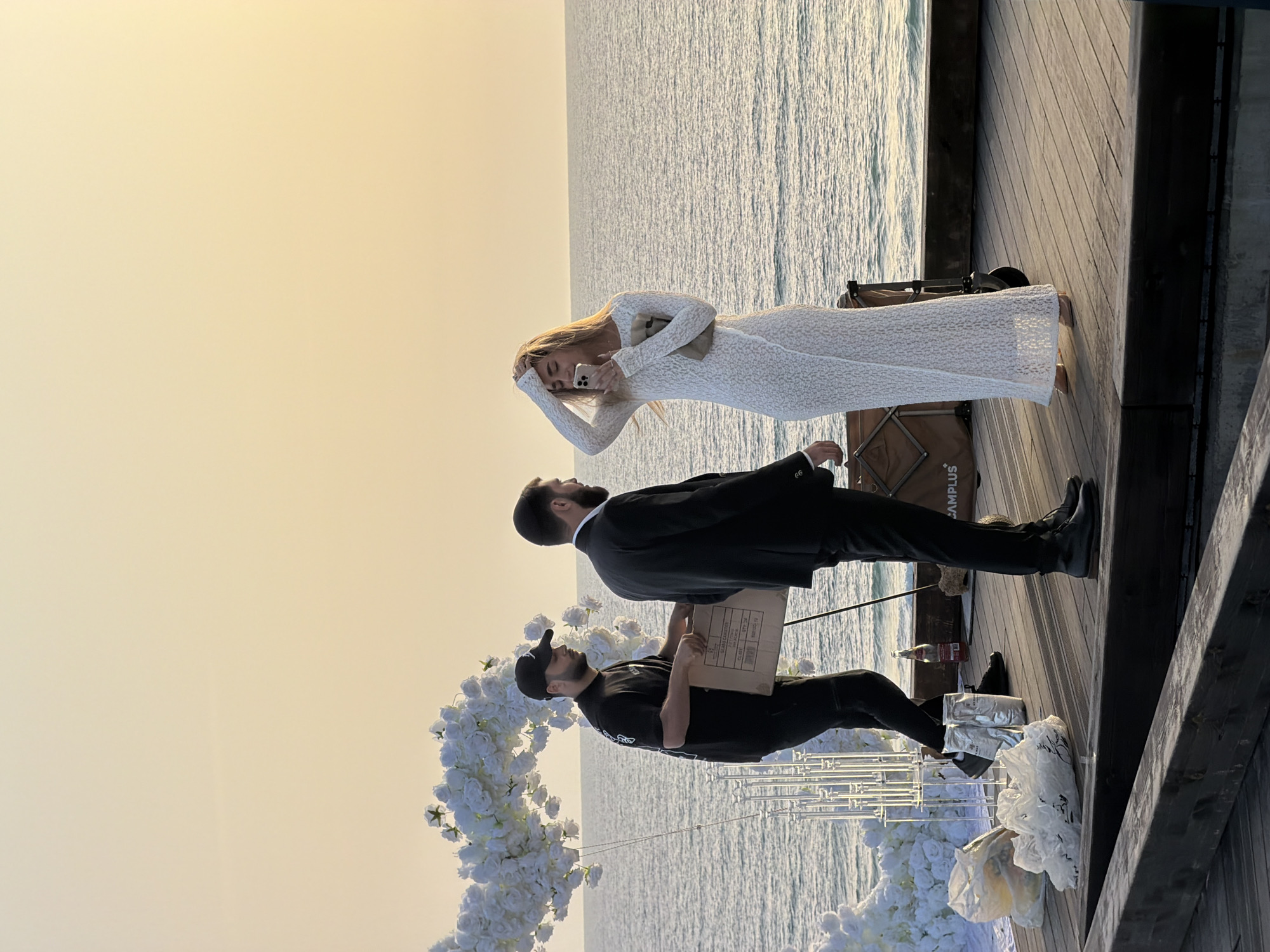 Three people gather on wooden pier in Bat Yam