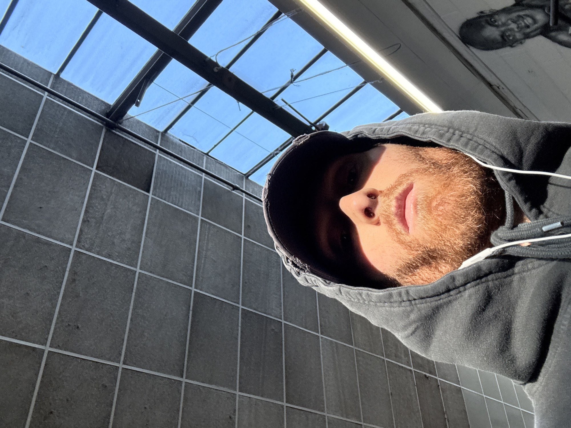 Person in hoodie photographed looking up indoors in London