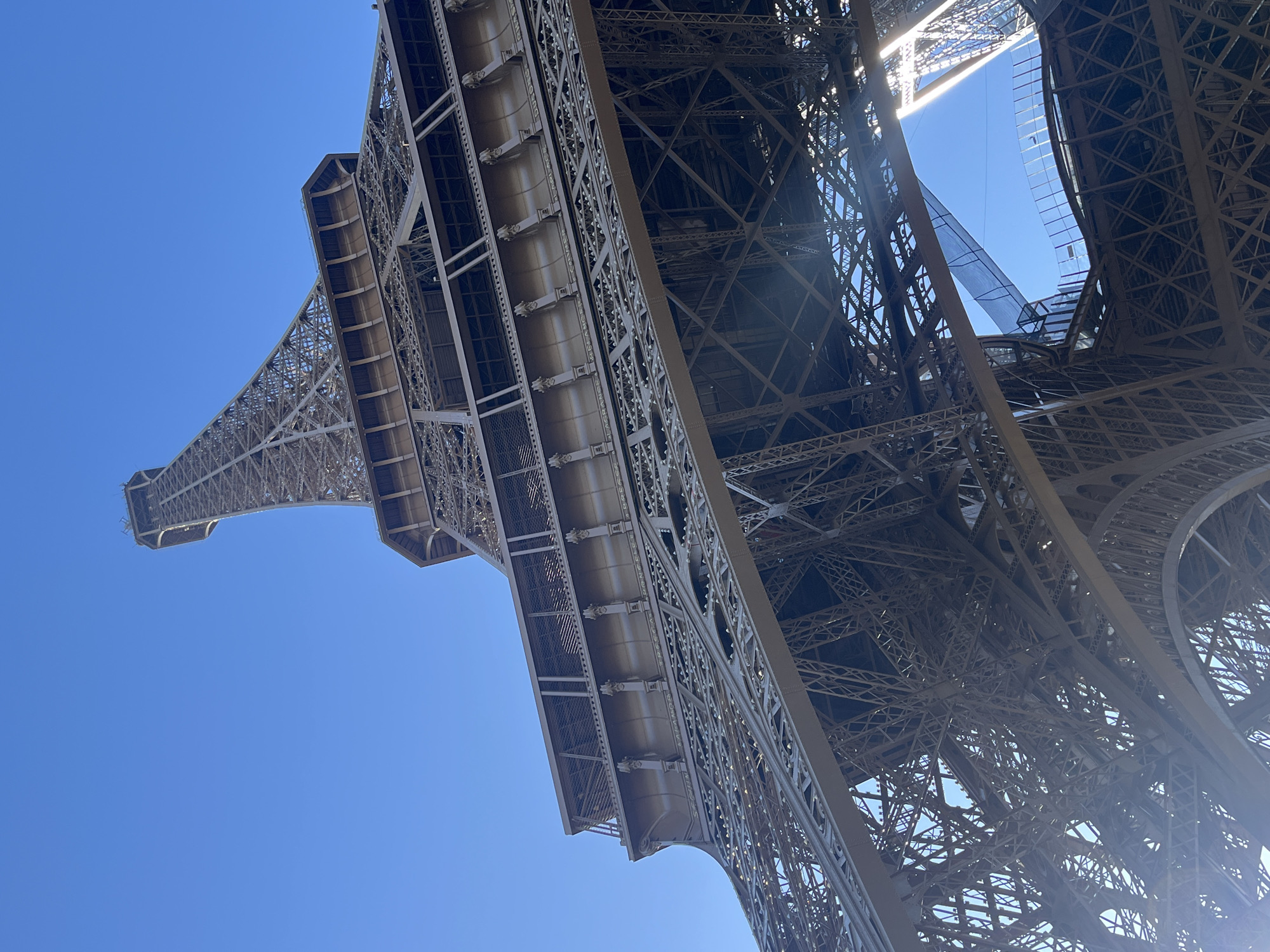 Morning visitors photograph Eiffel Tower under clear Paris skies
