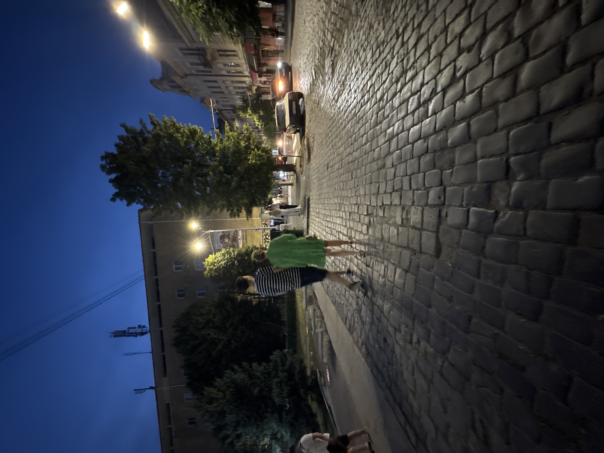 Chernivtsi city center at dusk, landmarks lit and streets active