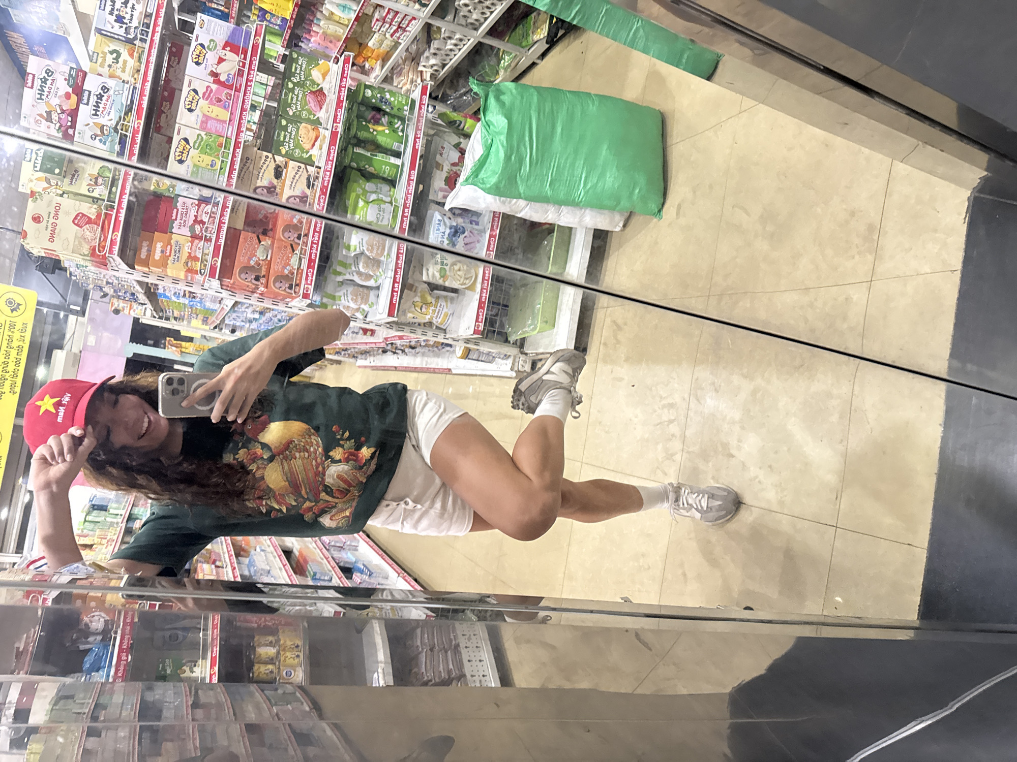 Tourist takes mirror selfie in Vietnamese store wearing patriotic cap