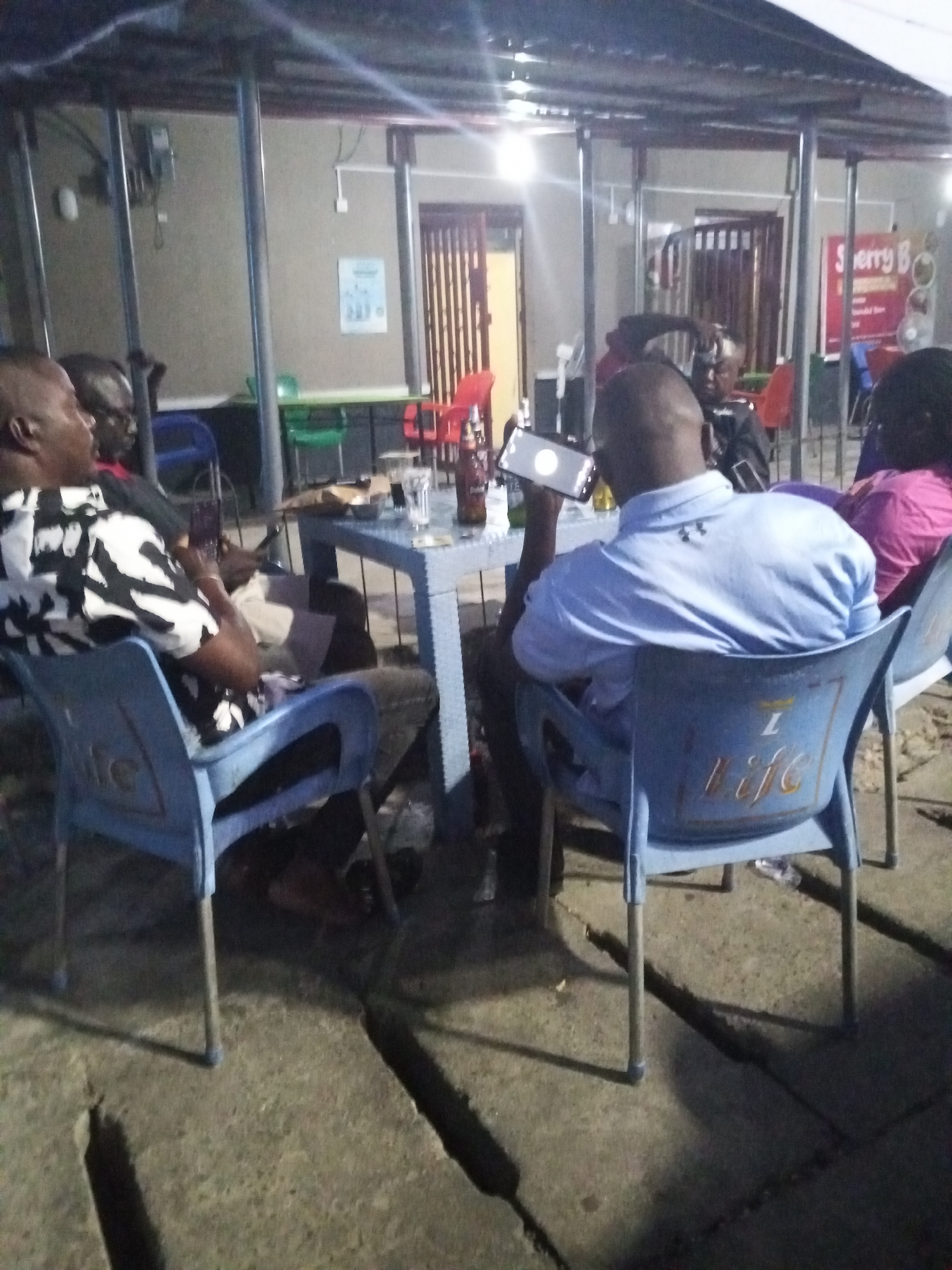 Evening social gathering at outdoor bar in Lokoja, Nigeria