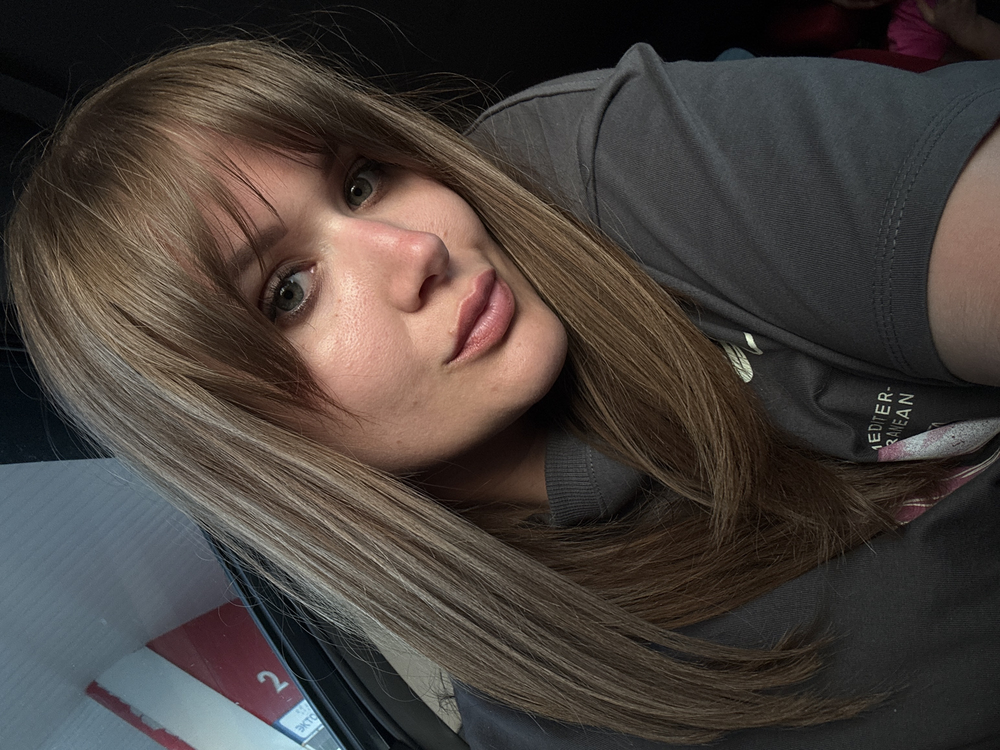 Woman takes selfie, captured in car mirror in Vinogradny