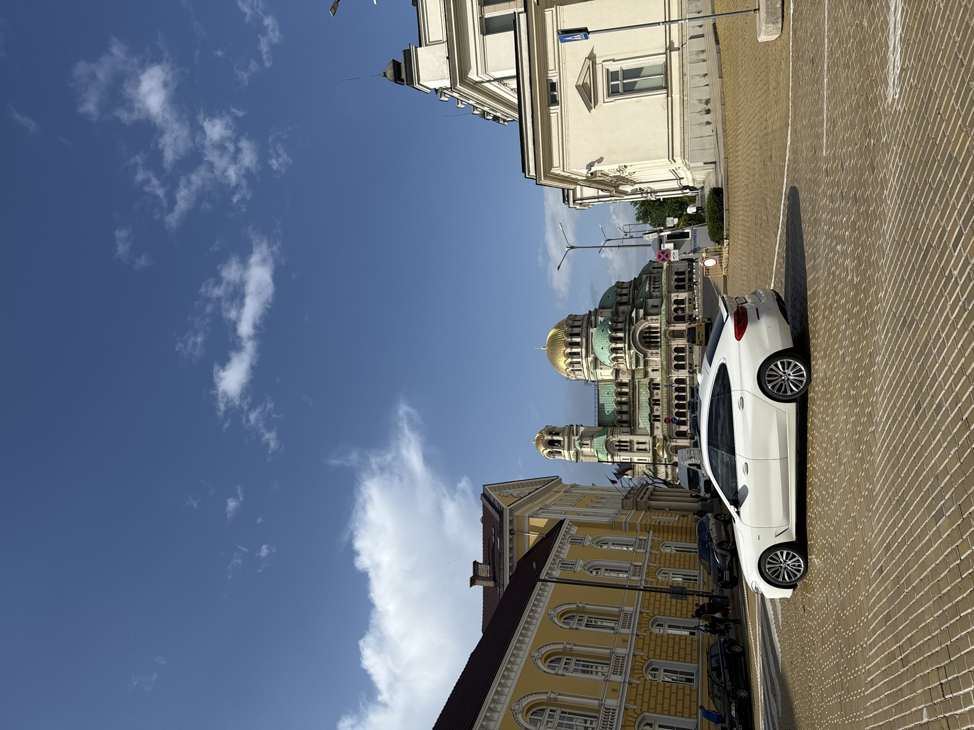 White car parked on cobblestone street in Sofia