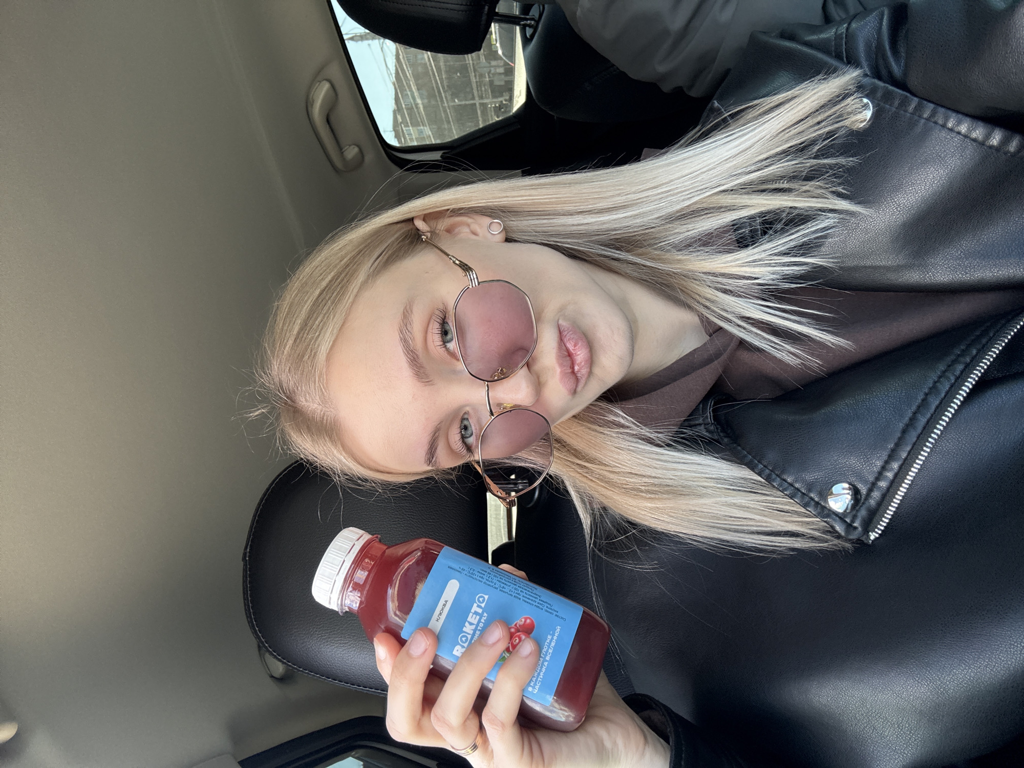 Woman enjoys cranberry juice in convertible car in Izhevsk