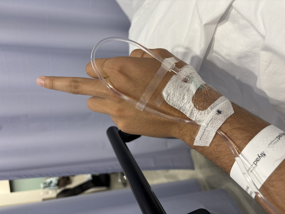 Hospital patient in León makes cheerful gestures during IV treatment