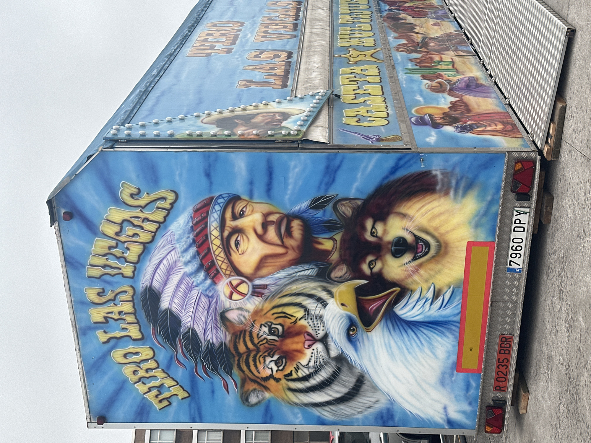 Colorful fairground trailer and waterfront scenes in Gijón
