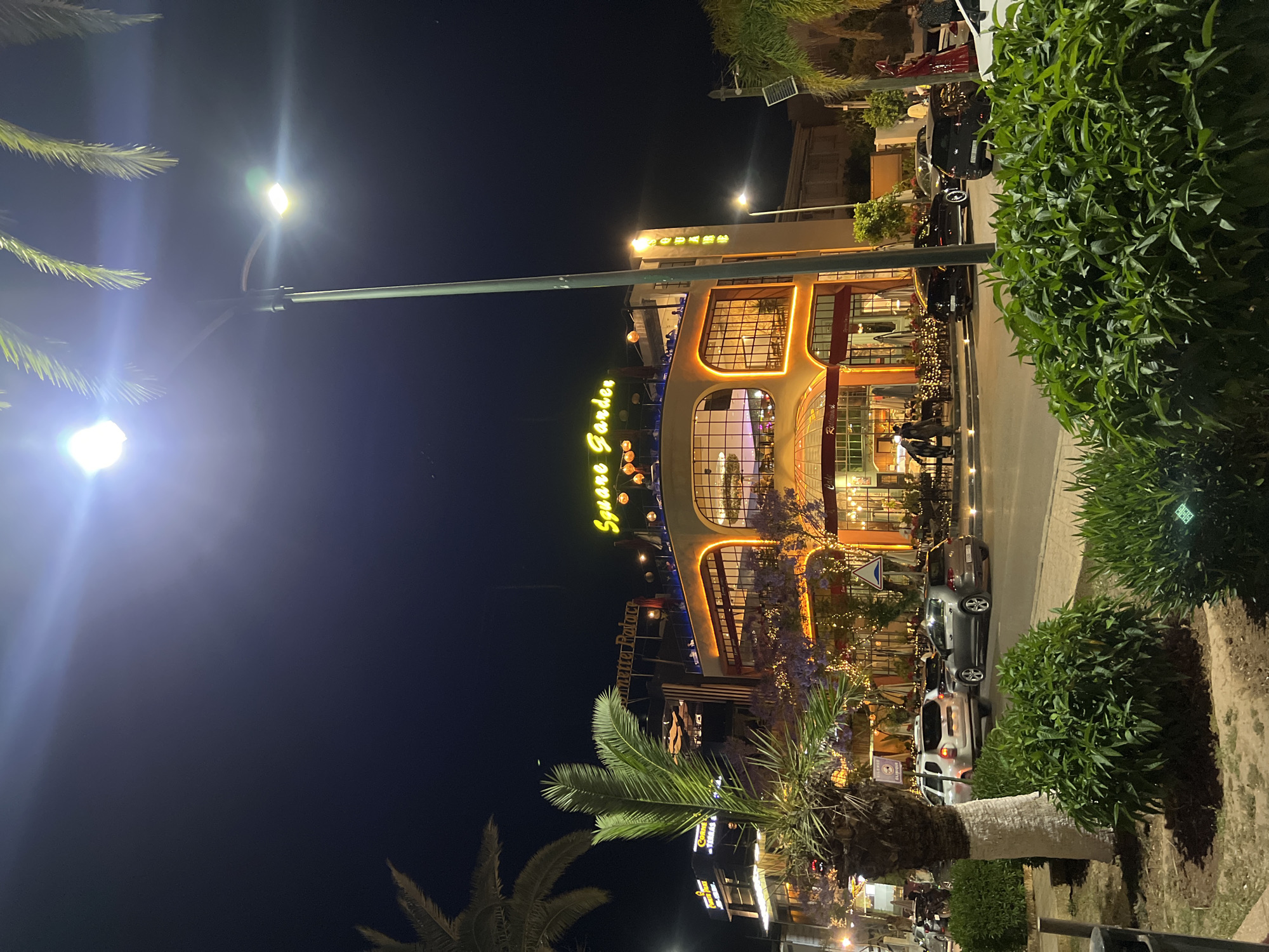 Evening gathering at illuminated Square Garden building in Meknes