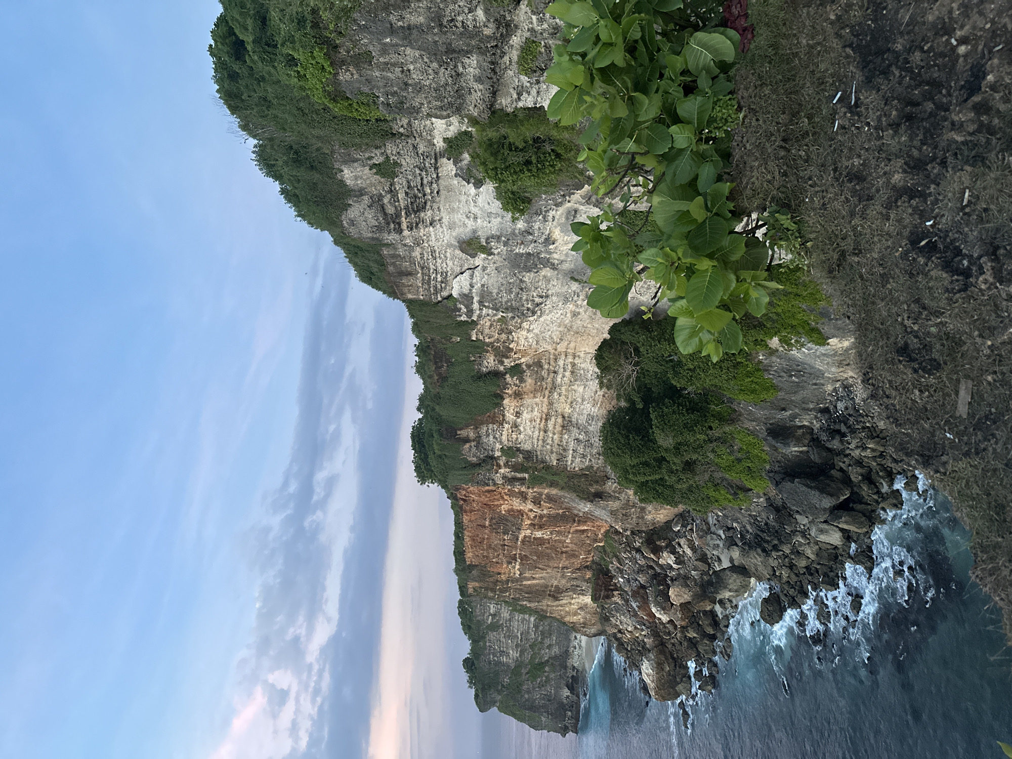 Tourists gather at Uluwatu cliffs during scenic sunset viewing