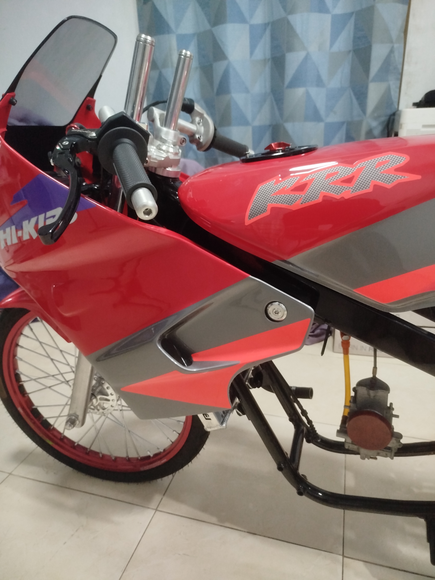 Custom red motorcycle on display at a Si Sunthon workshop