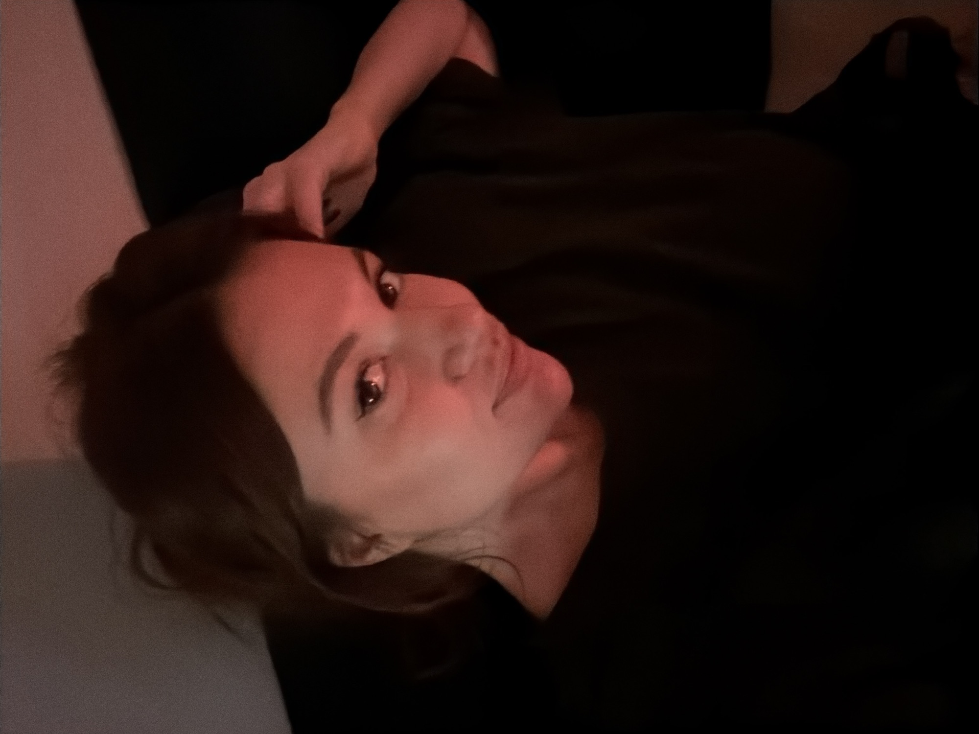 Woman rests in dimly lit Belgrade apartment at night