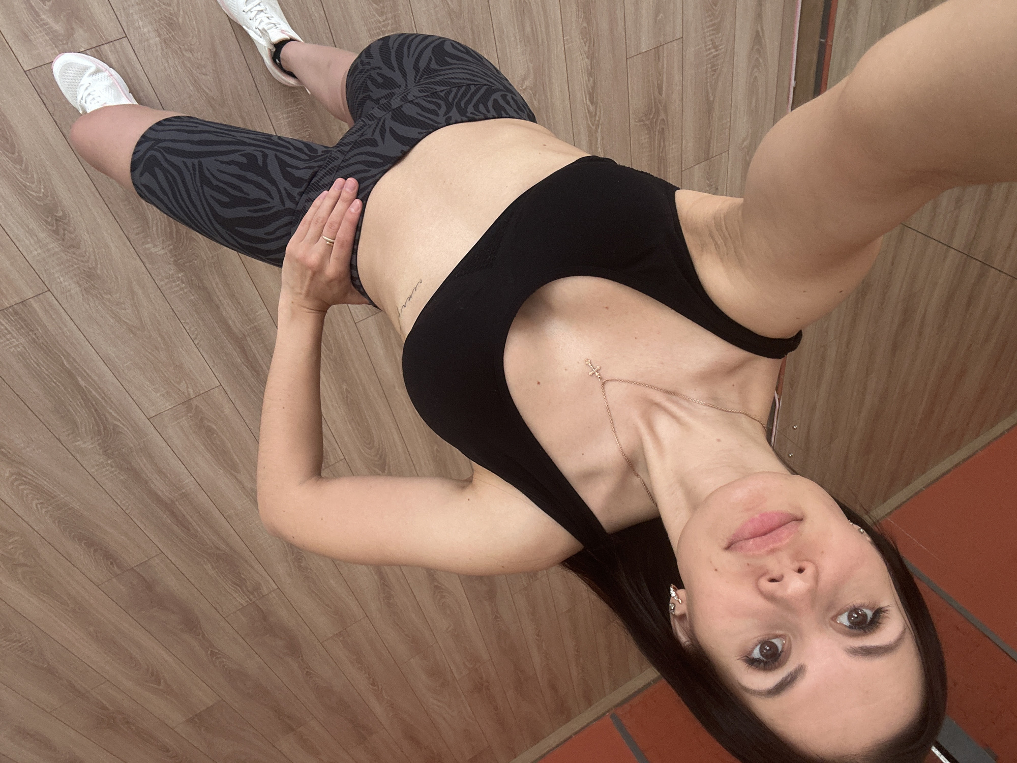 Woman takes workout selfies in athletic wear indoors