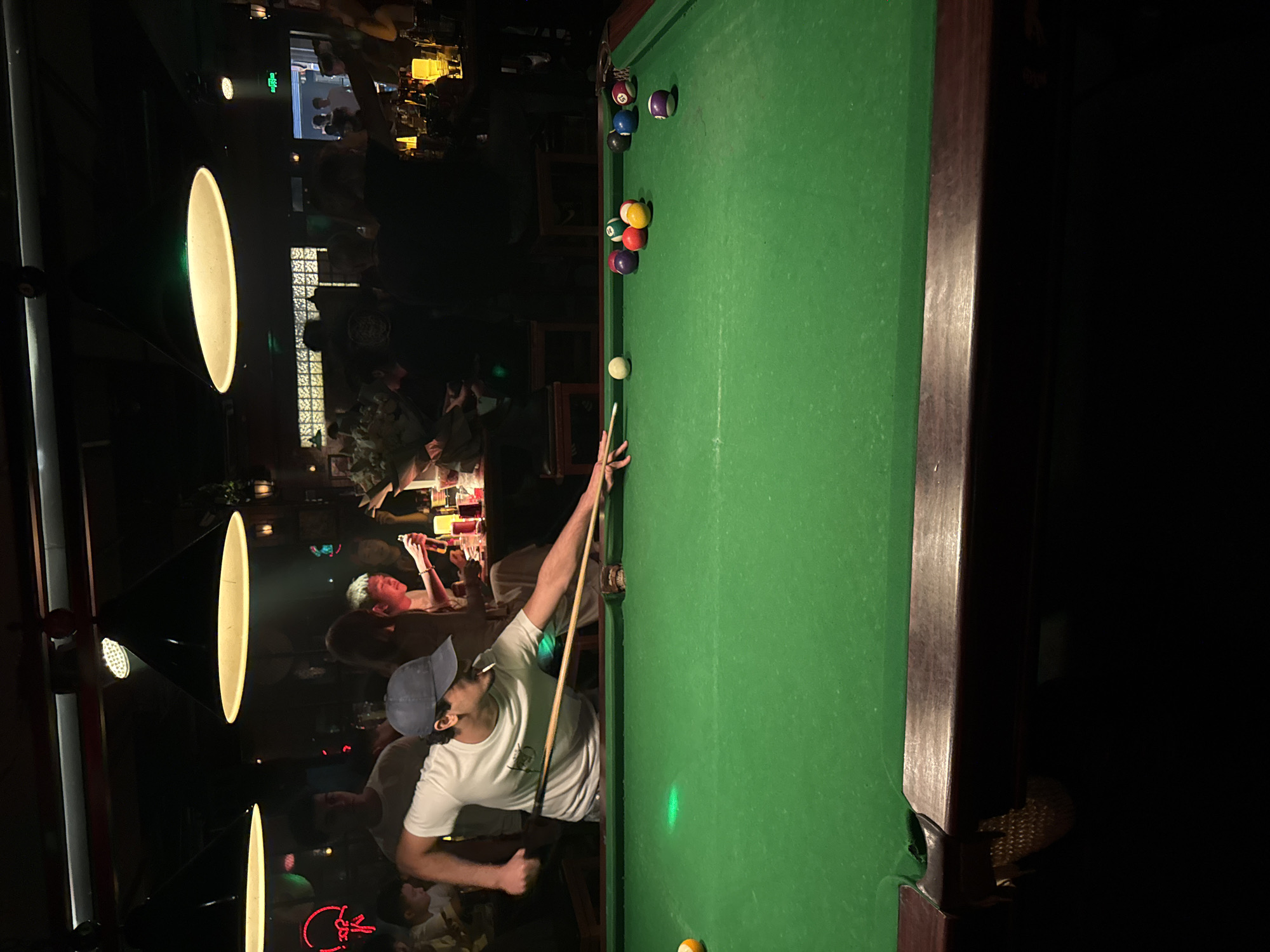 Man plays pool at dimly lit Liangjiang bar