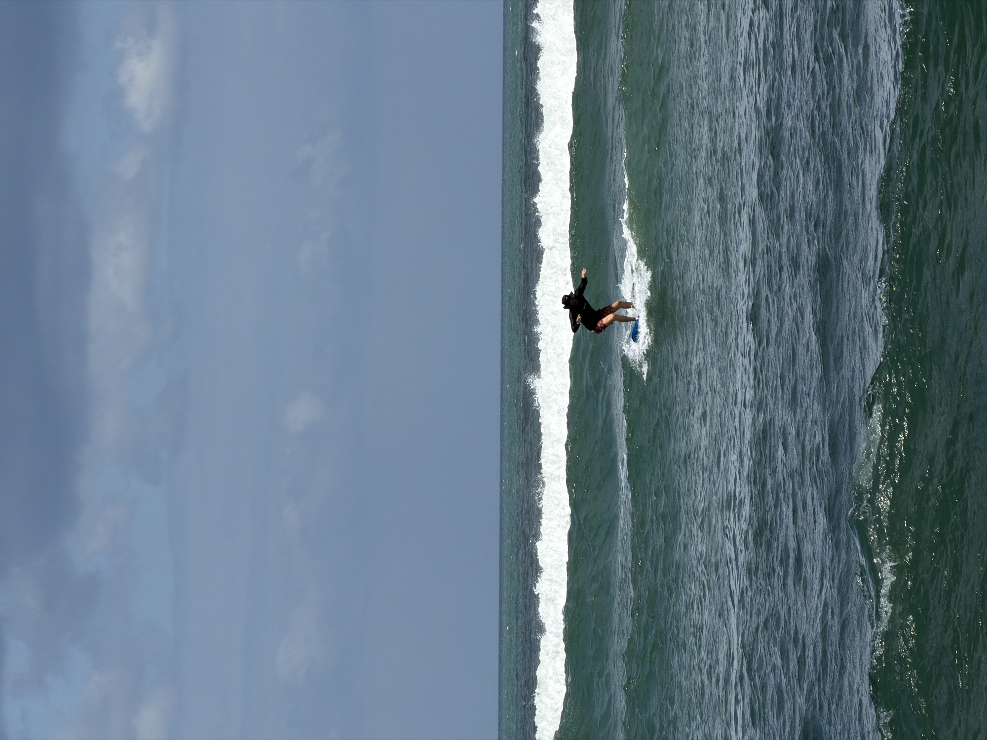 Active surf scene on North Kuta's dark sand beach