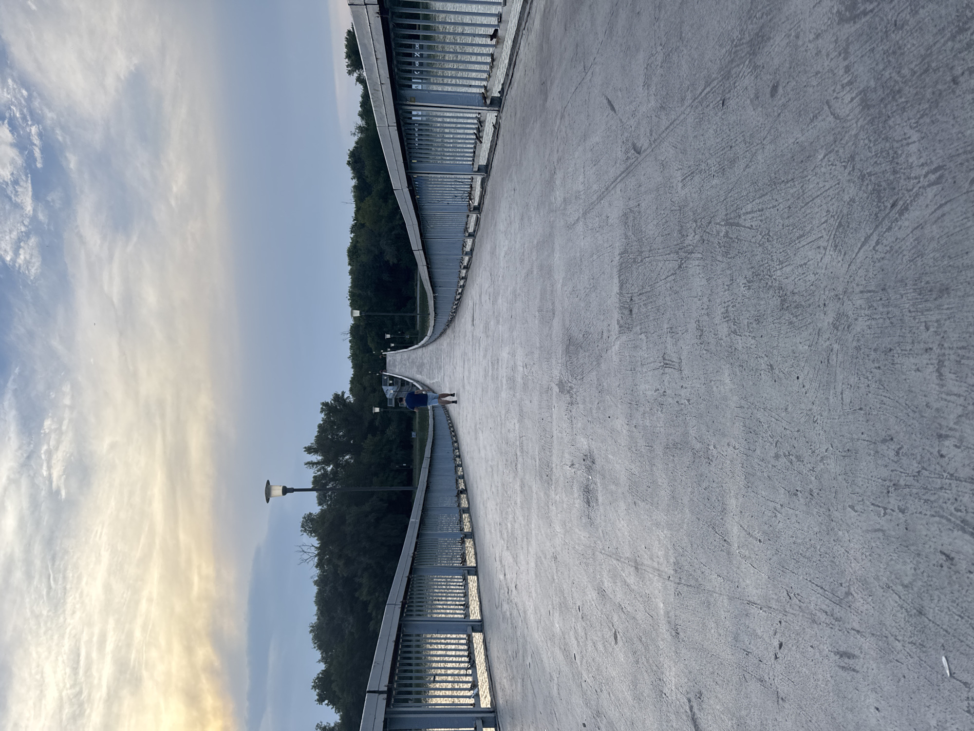Walking Plovdiv's arched pedestrian bridge over calm water