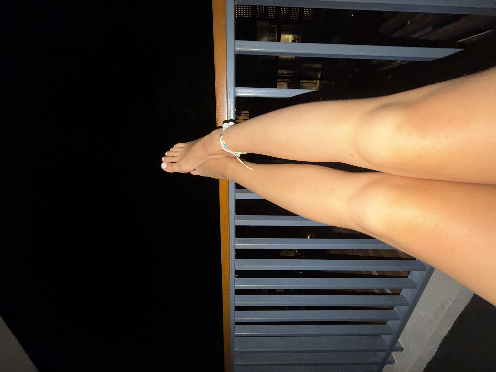 Feet up on a railing over Bang Muang's nighttime skyline
