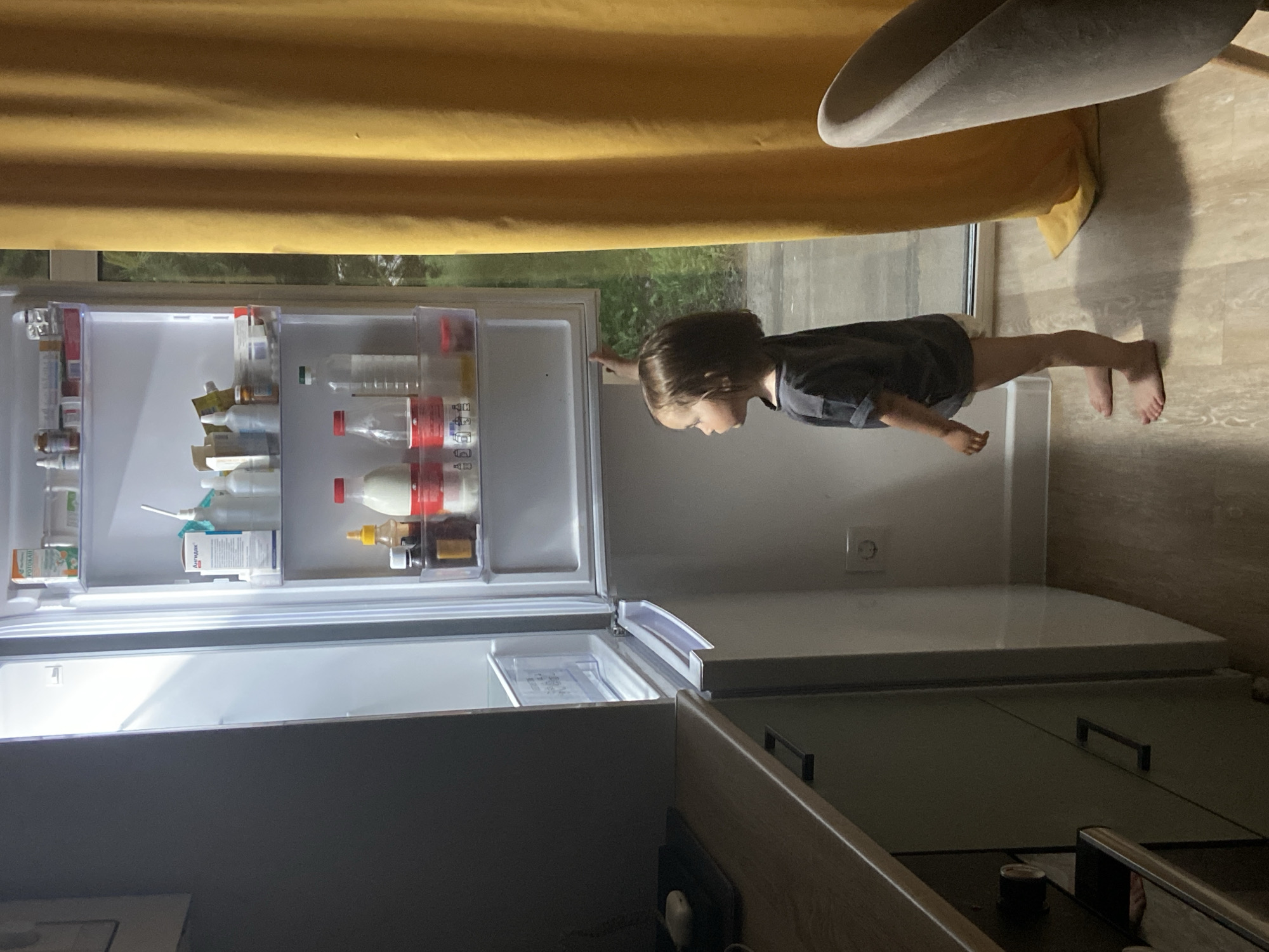 Child explores kitchen during rainy afternoon in Tyumen